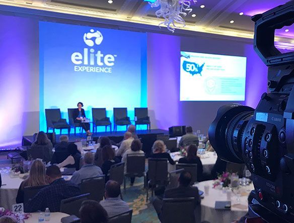 Conference panel on stage with blue 