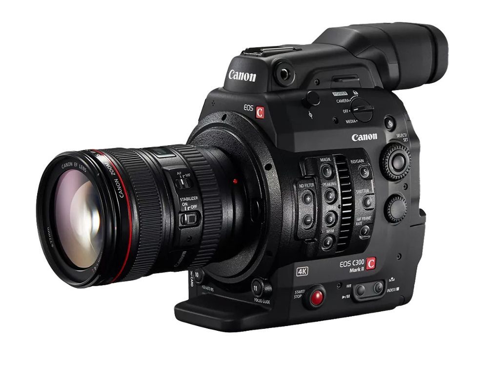 Black Canon DSLR video camera with large lens and top viewfinder on a white background