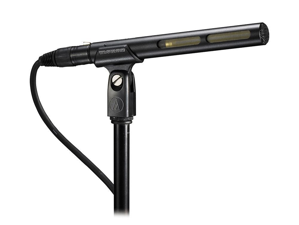 Black handheld microphone on a stand with a cable attached