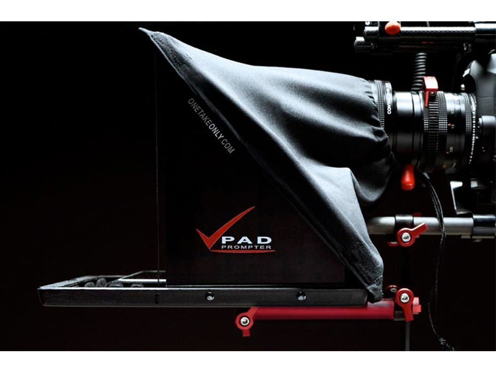 Black covered camera rig with red accents on a motion-control slider against a dark background