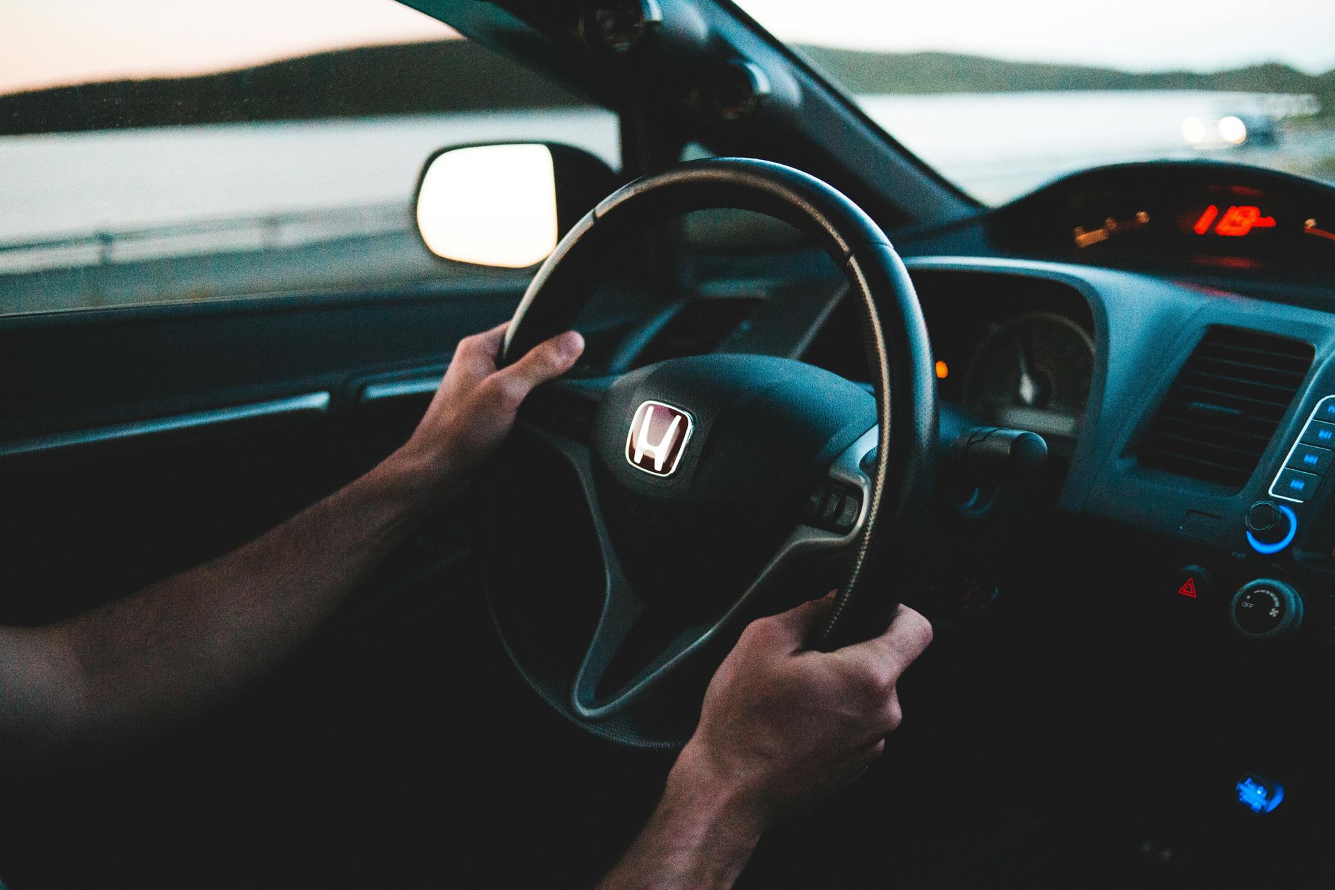 A family is sitting on the porch of their house next to a swimming pool.