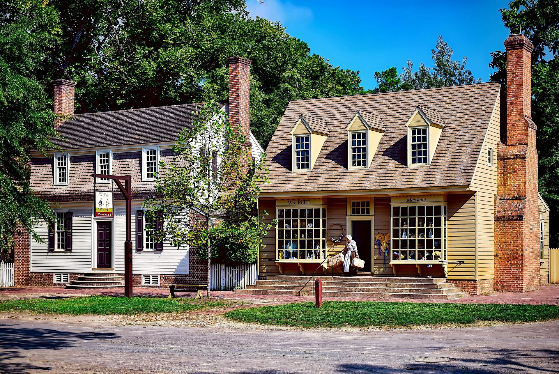 A delivery man is giving a package to a woman in front of a van.