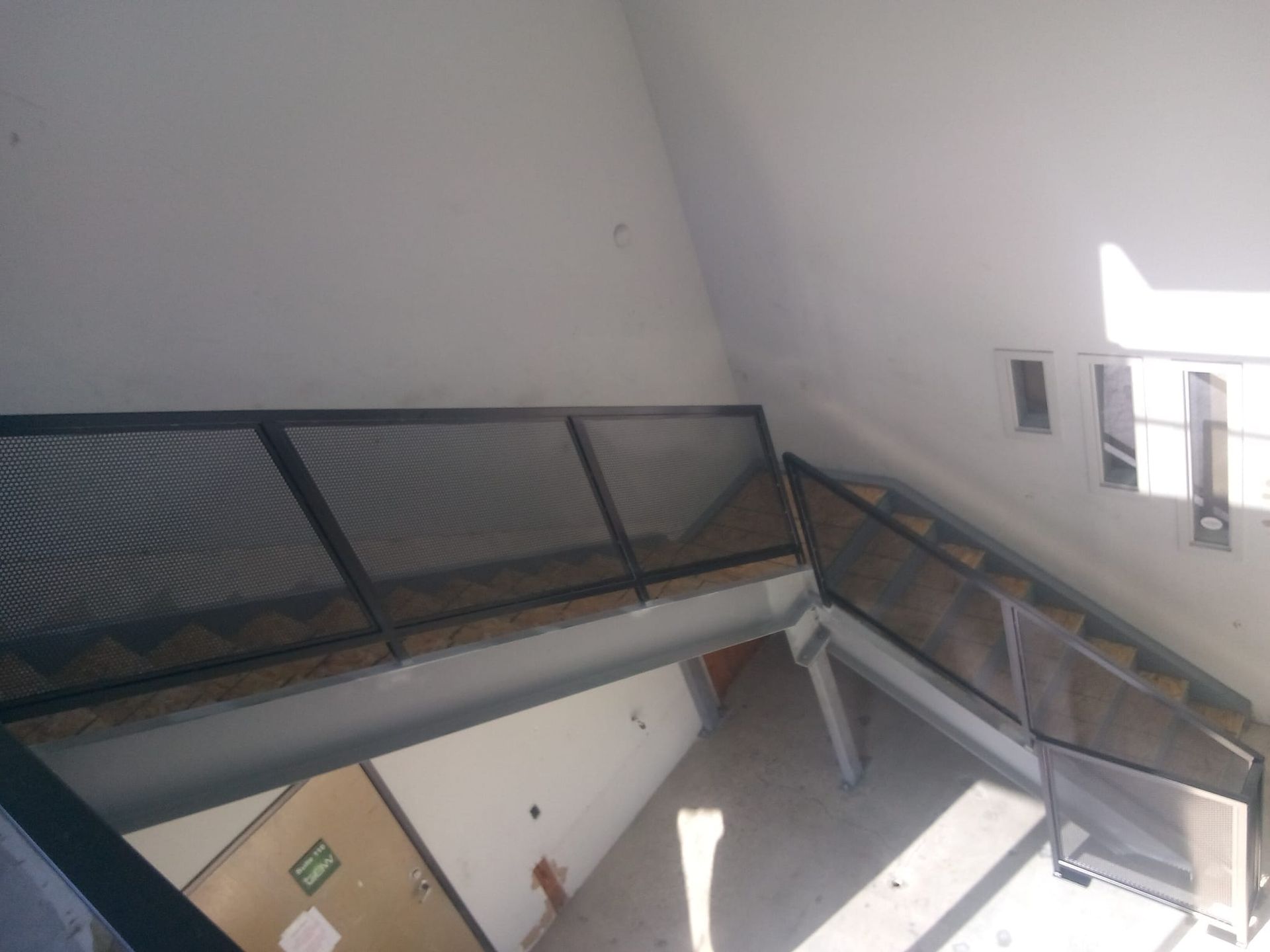 A room with a green exit sign on the door