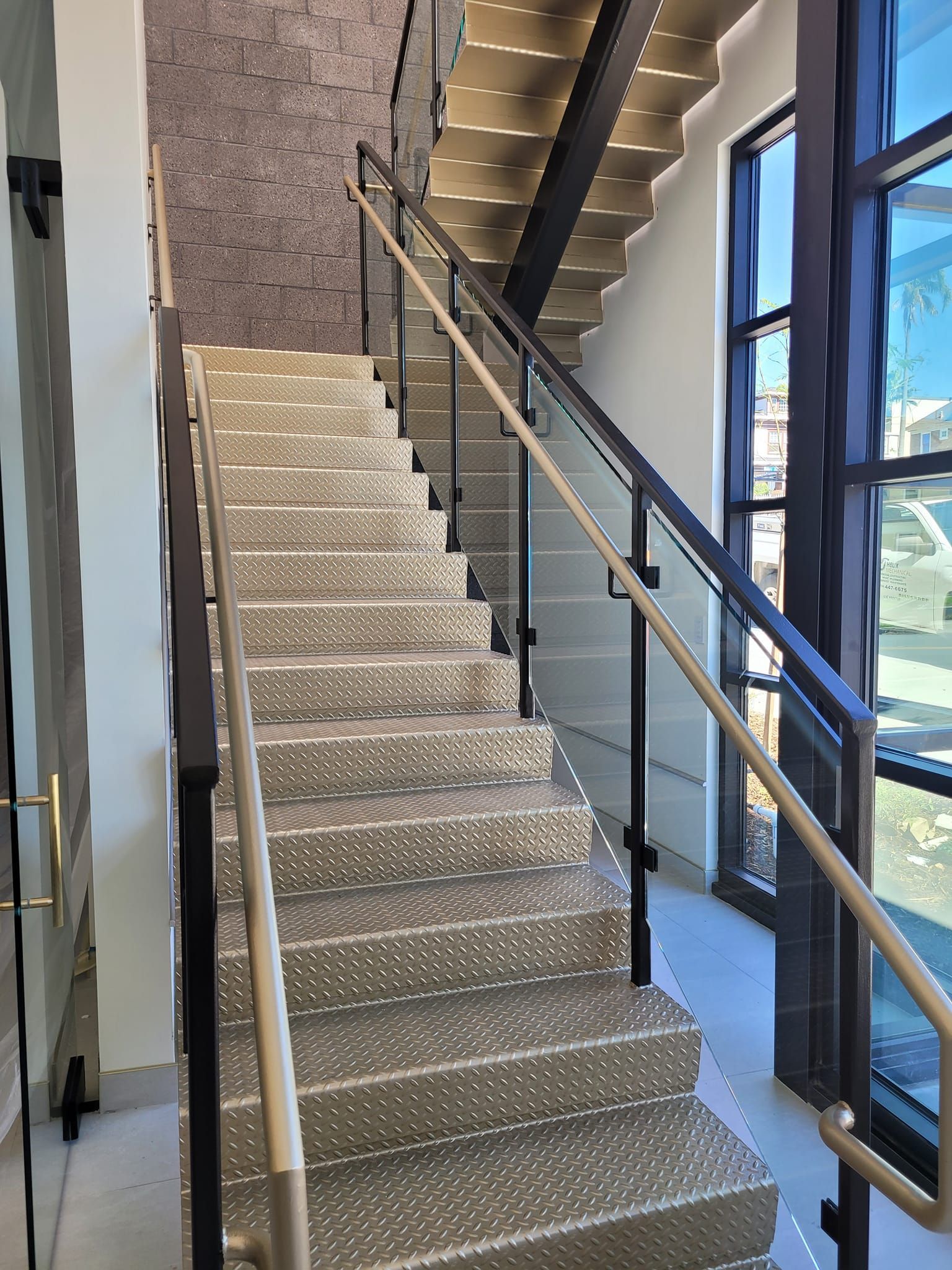 A staircase with a glass railing and steps in a building.