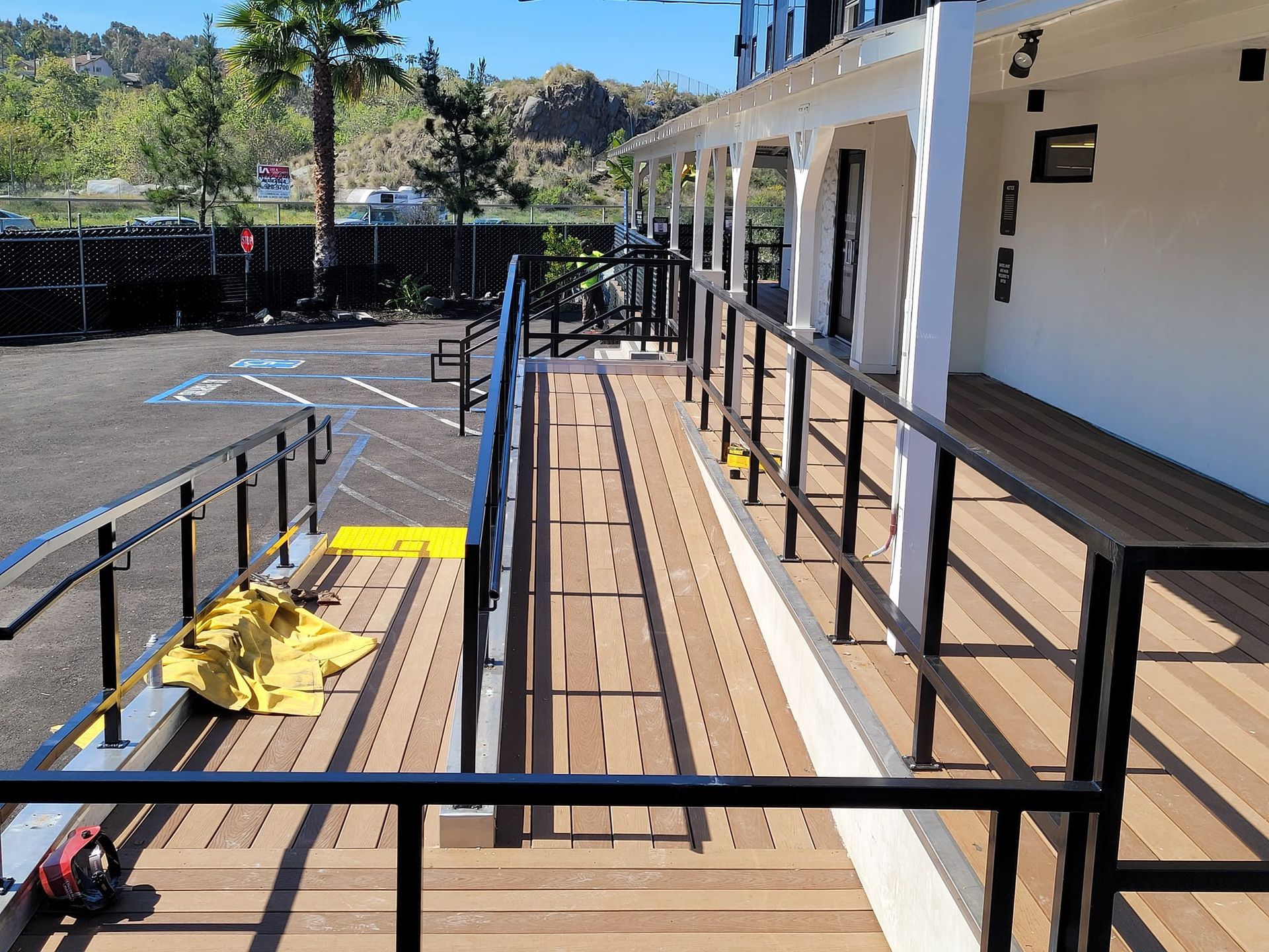 A wooden deck with stairs and a black railing