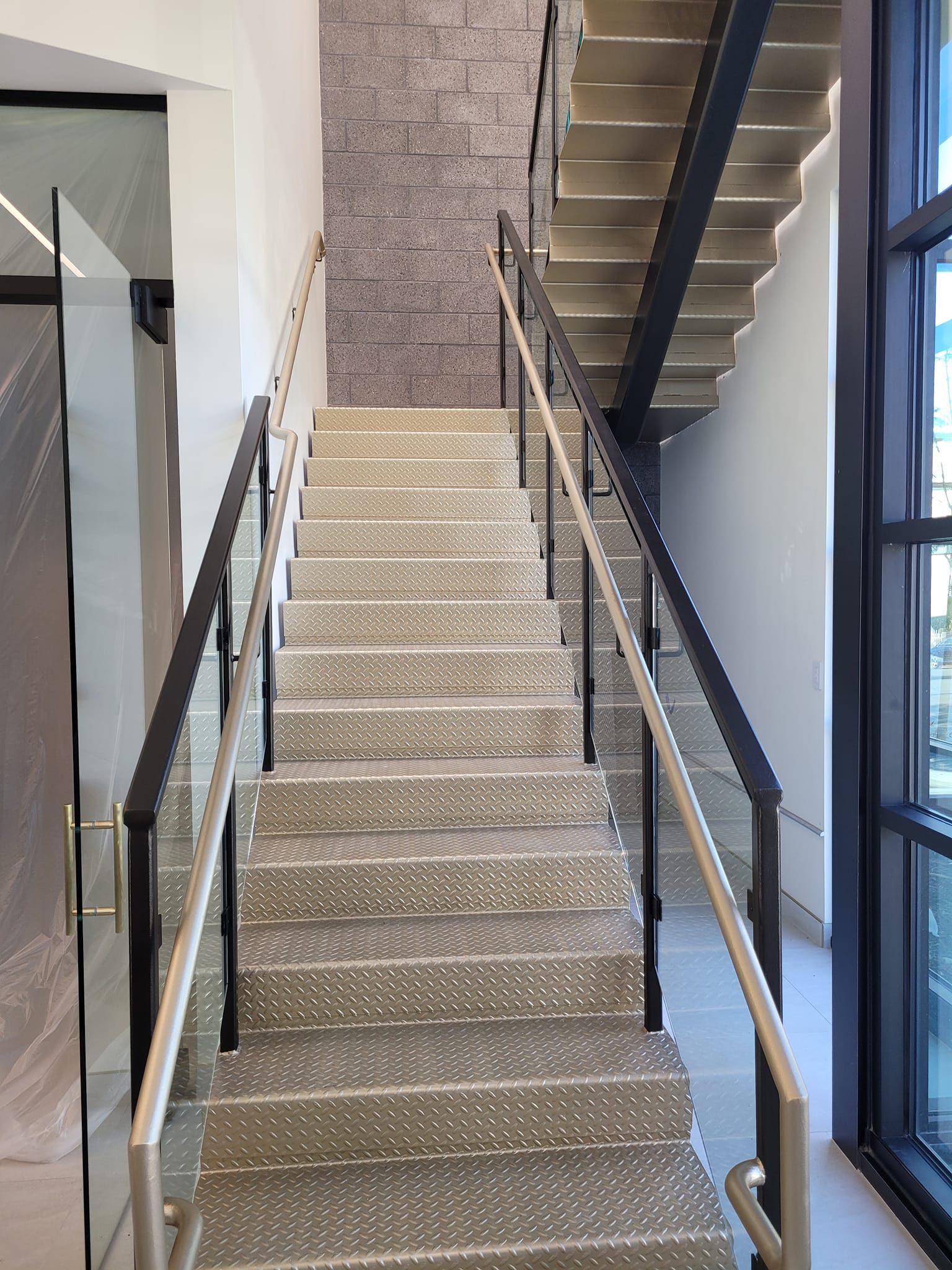 A set of stairs with a glass railing in a building.