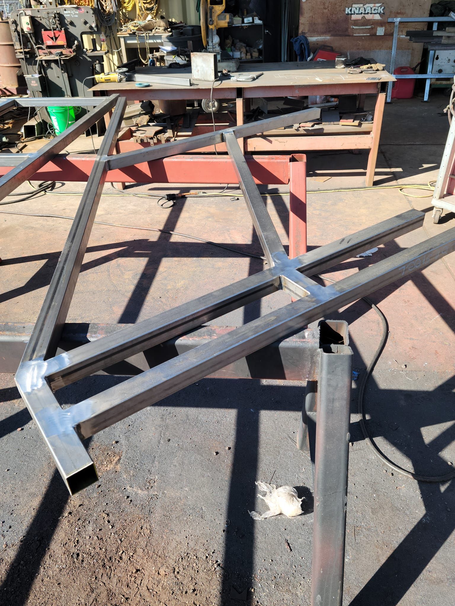 A piece of metal is sitting on the ground in a workshop.