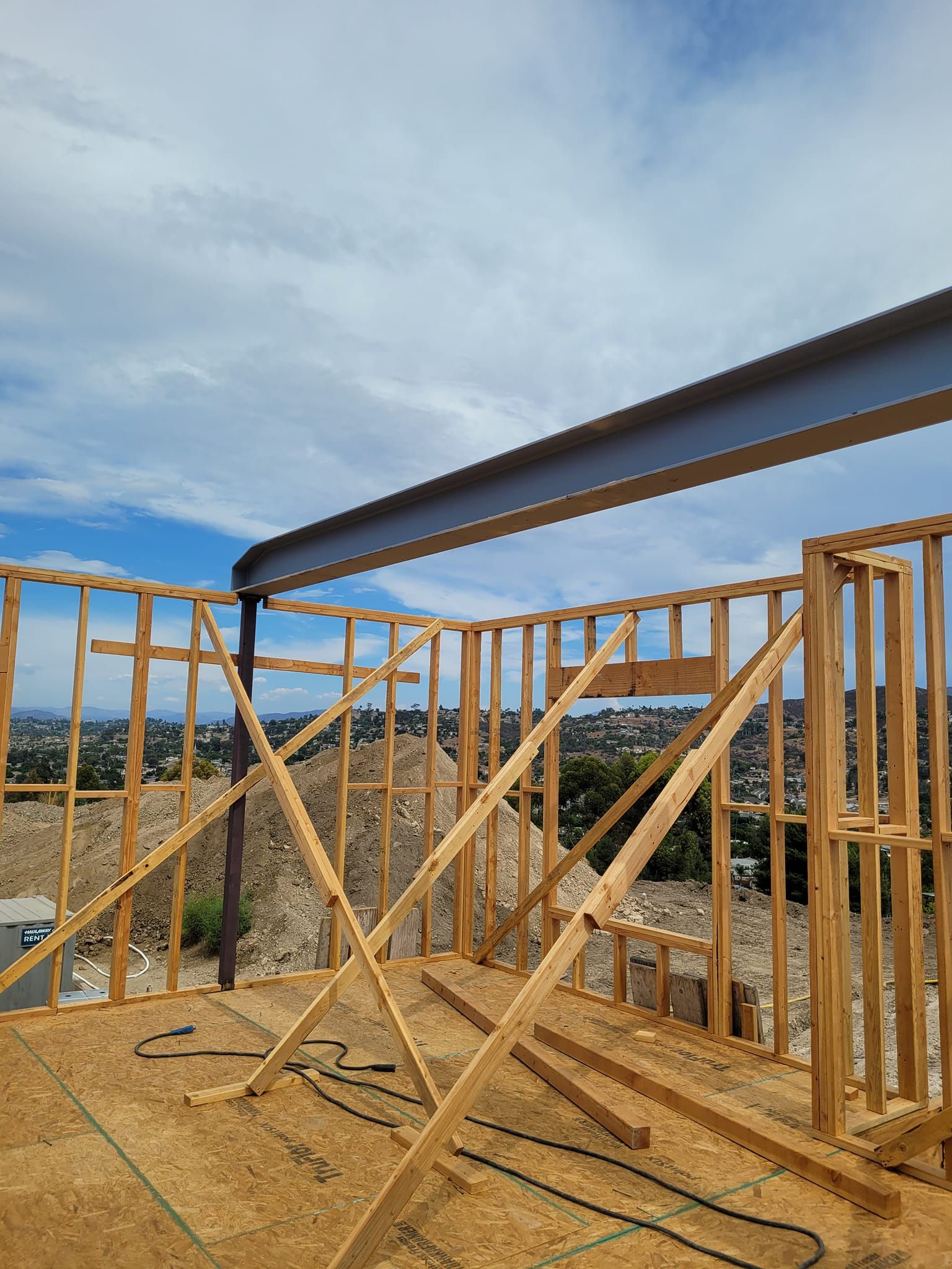 A house is being built with wooden beams and a metal beam.
