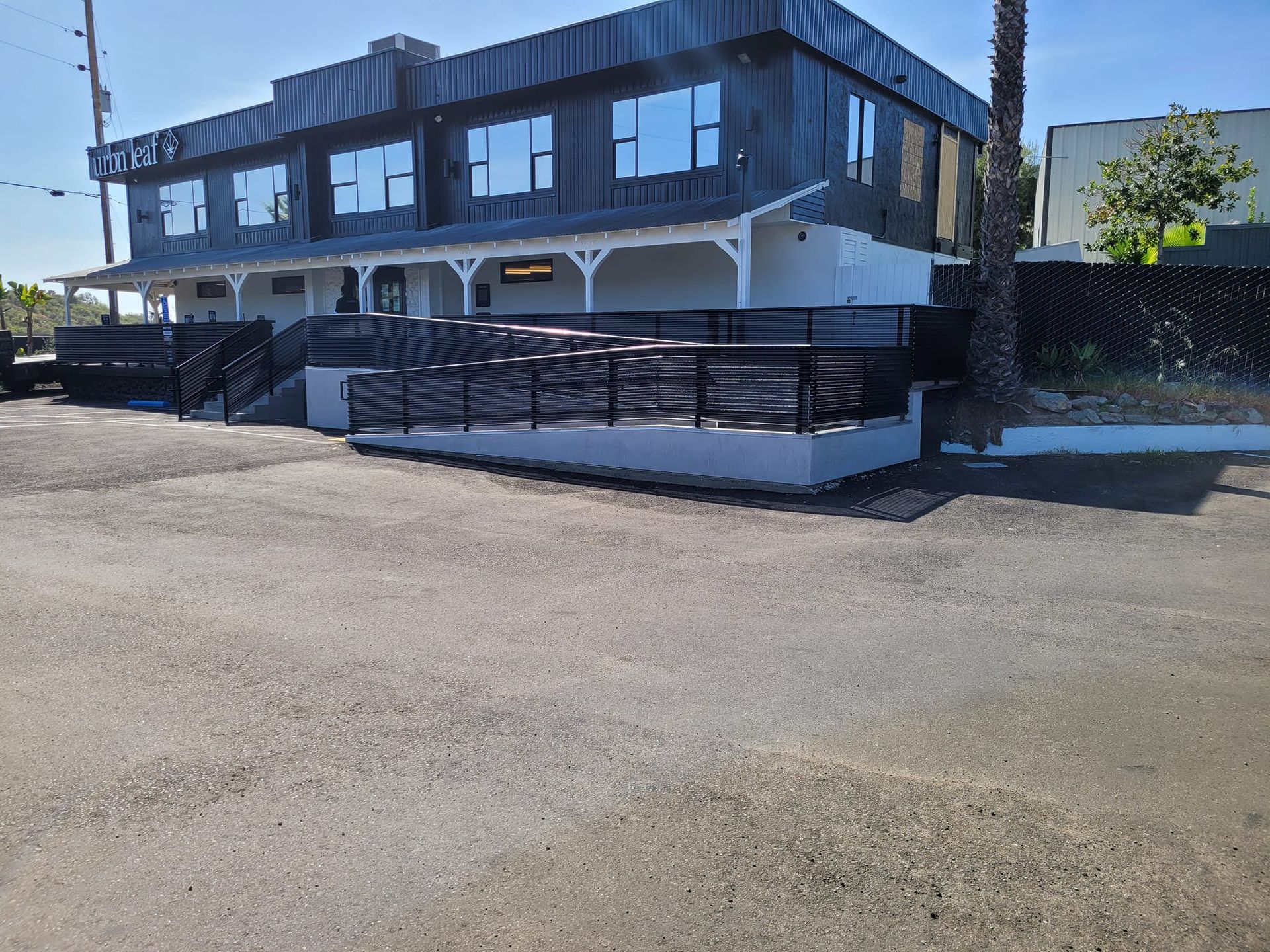 A large building with a lot of windows is sitting on the side of the road.