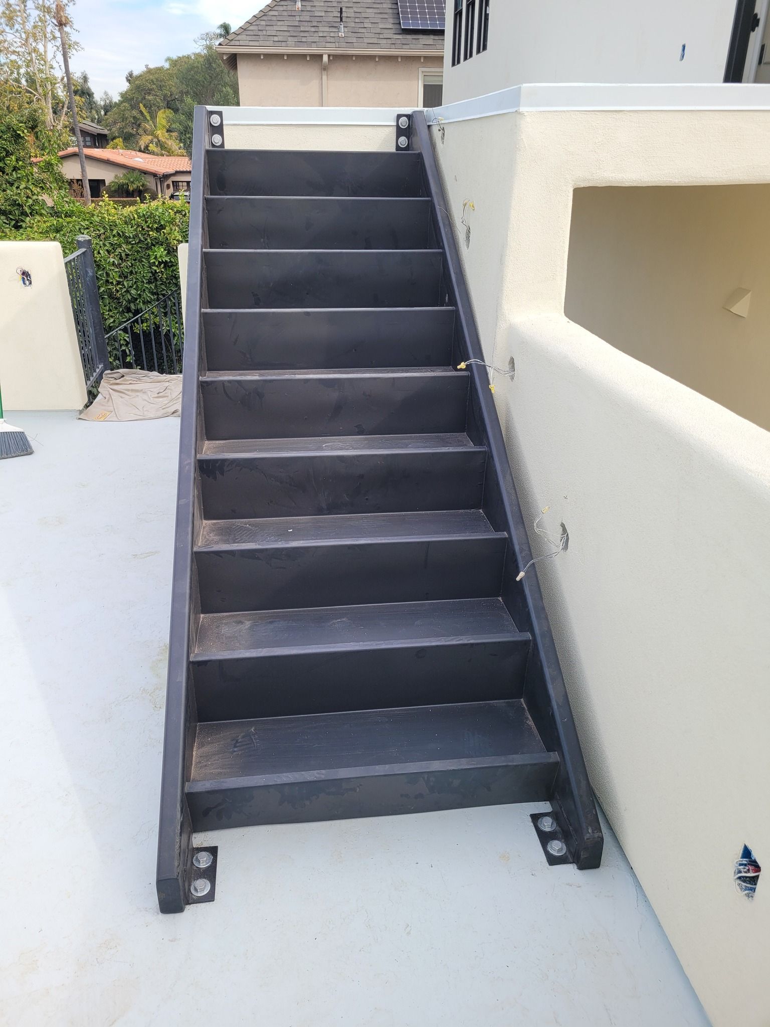 A set of black stairs leading up to a white building