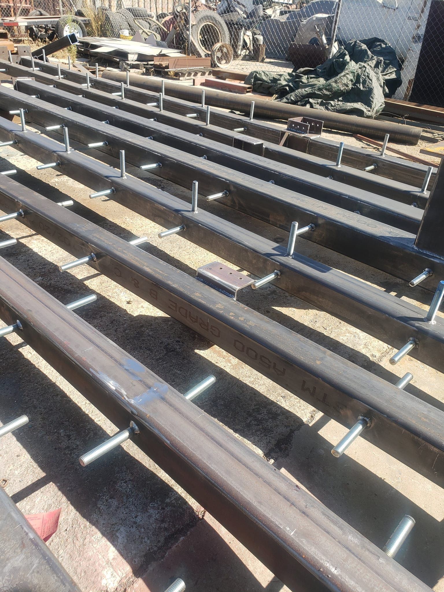 A bunch of metal rails are sitting on top of a wooden deck.