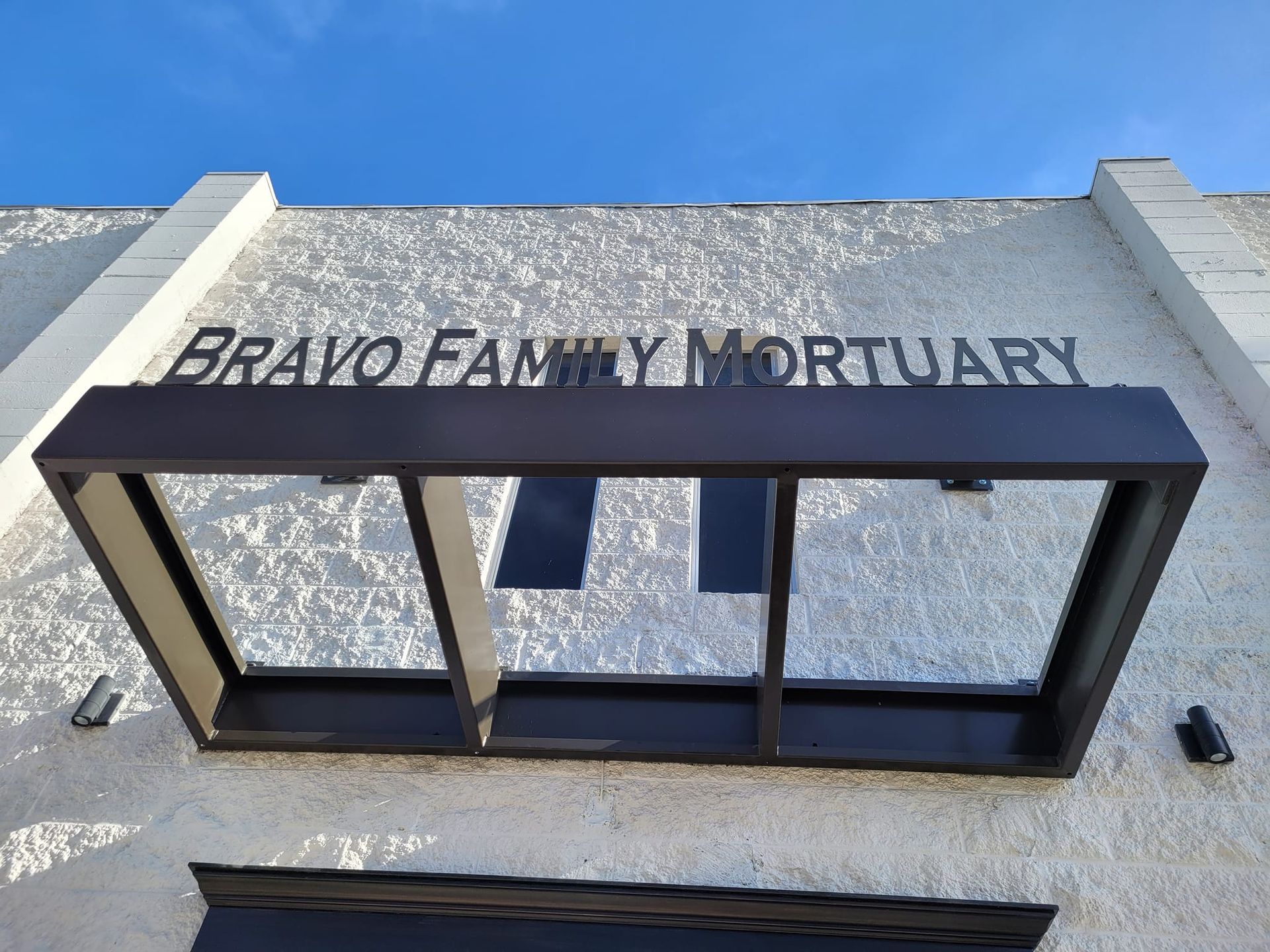 A sign on the side of a building that says bravo family mortuary