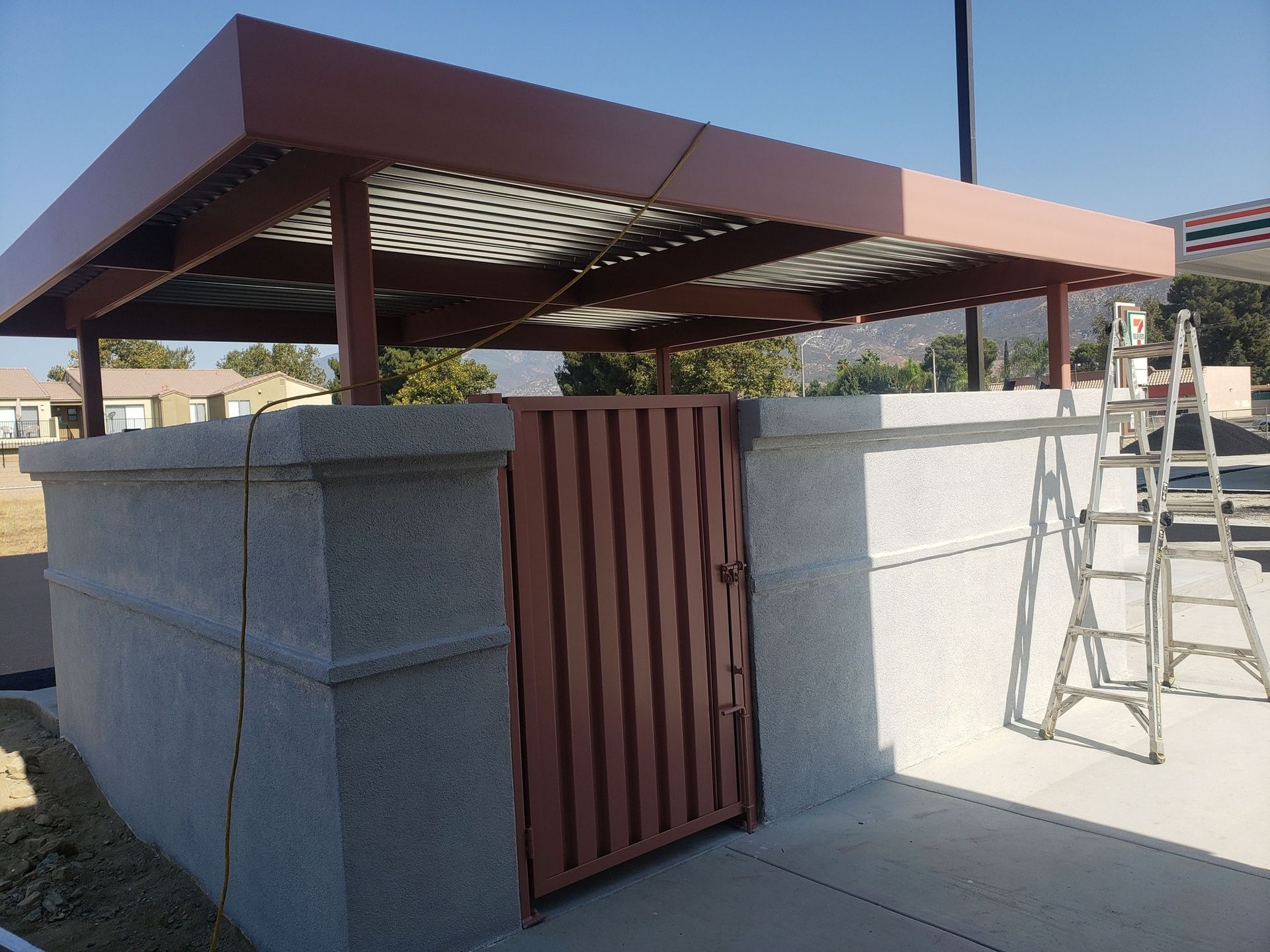 A shed with a gate and a ladder in front of it