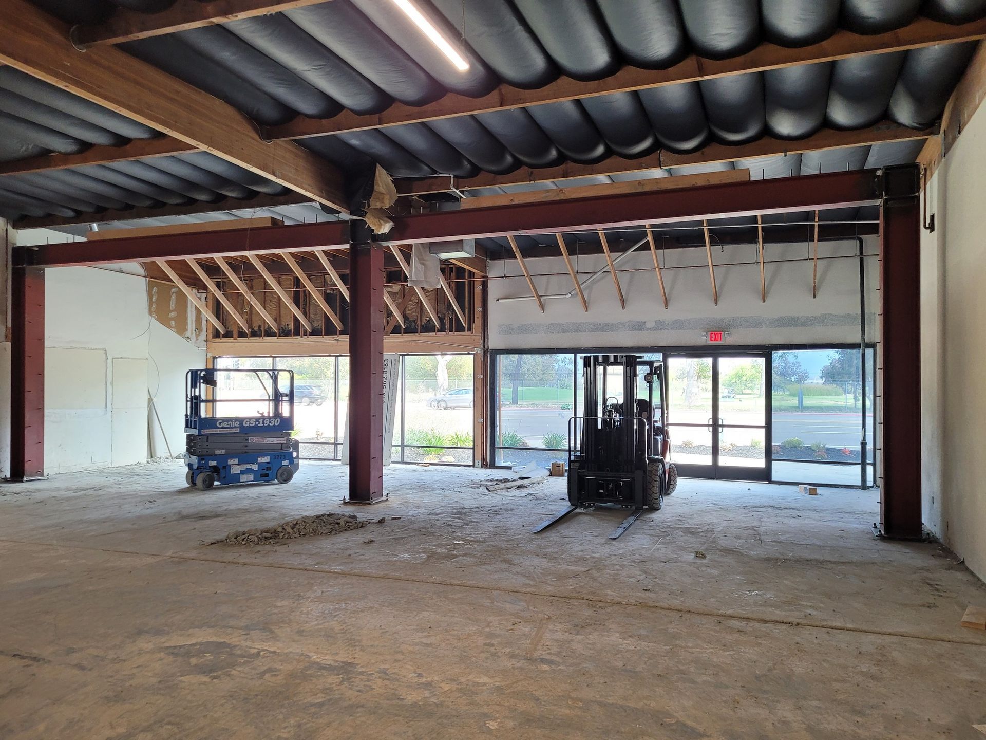 An empty building with a forklift in the middle of it.