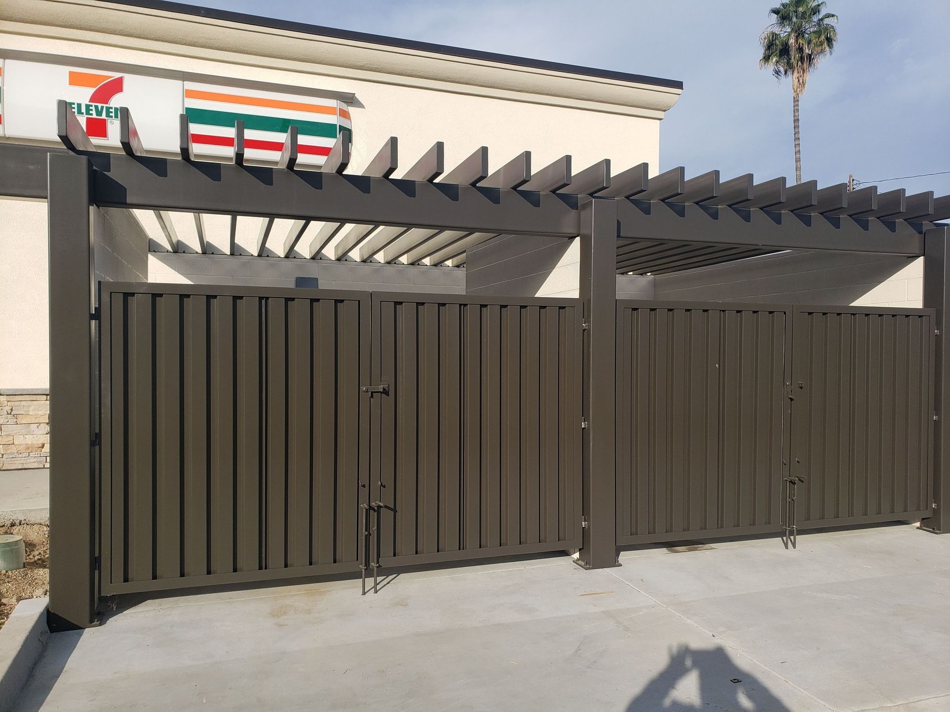 A 7 eleven store with a pergola and a gate