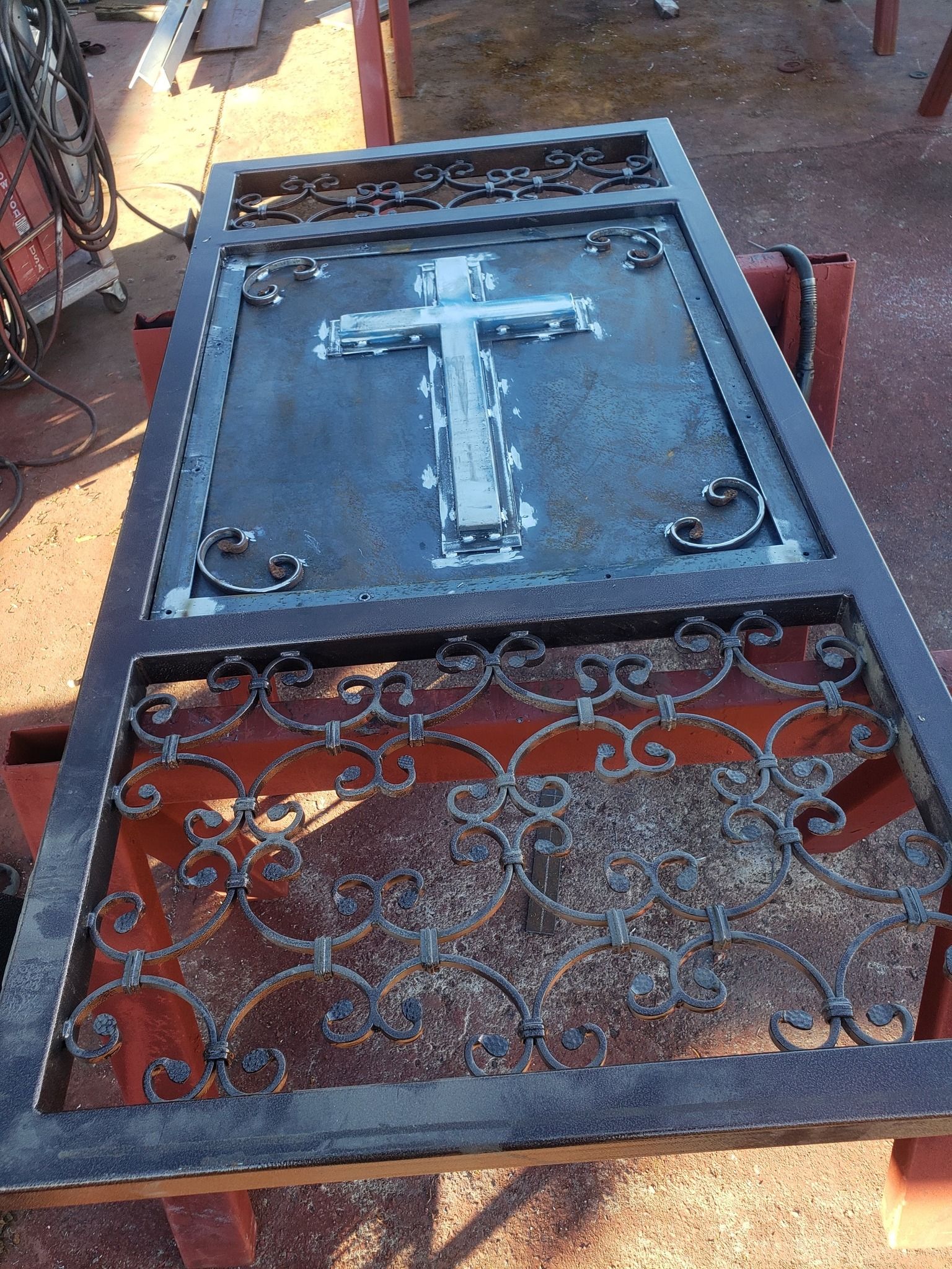 A piece of metal with a cross on it is sitting on a table.