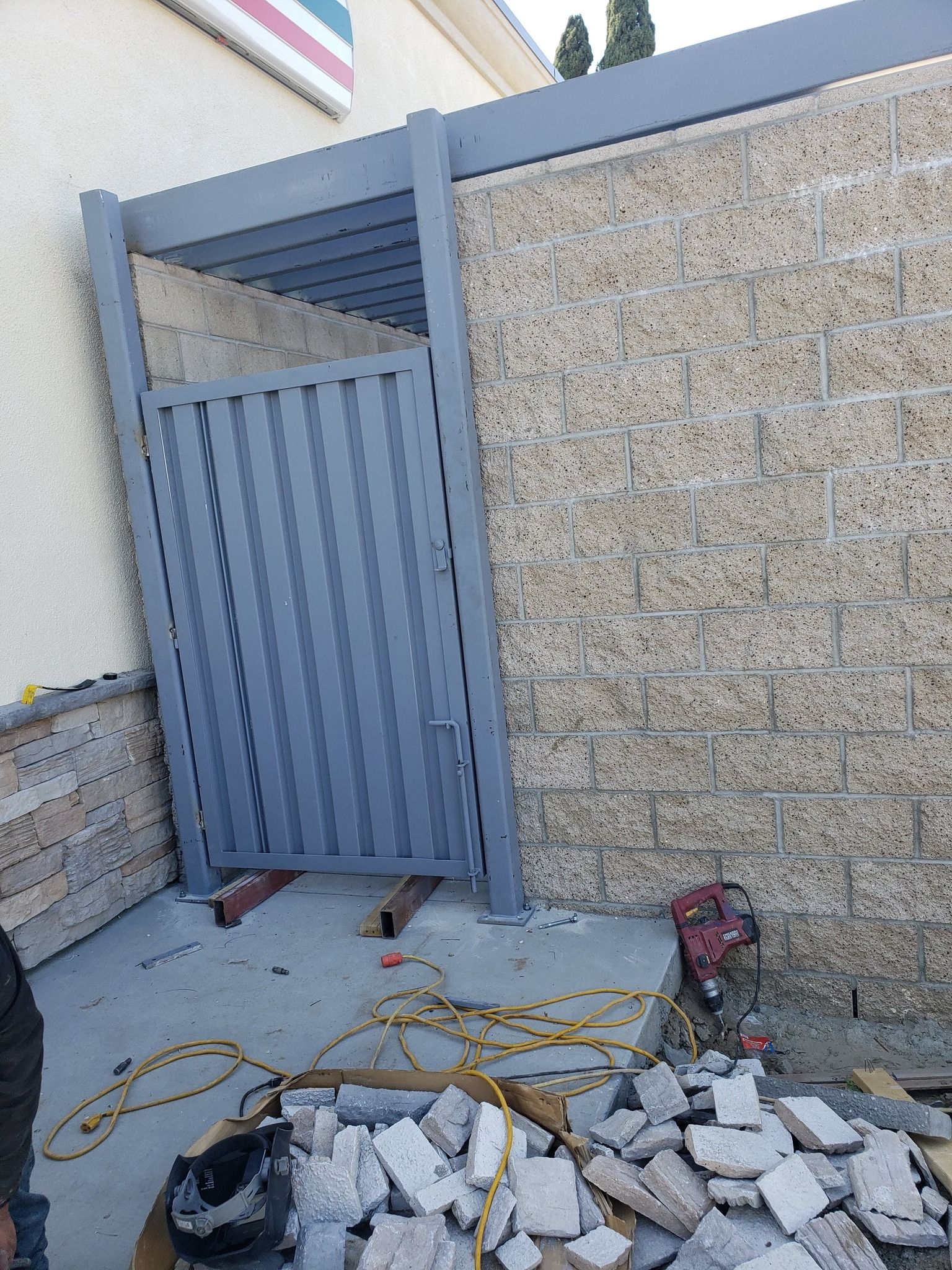 A fence is being built next to a brick wall.