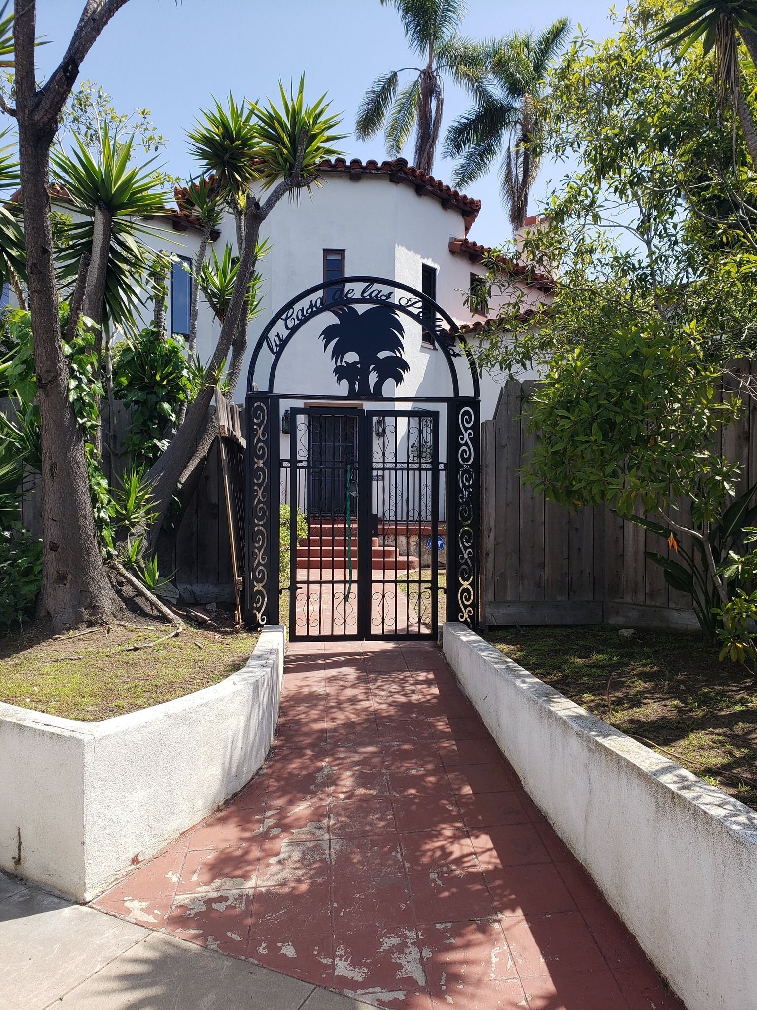 A walkway leading to a house with a gate in front of it.