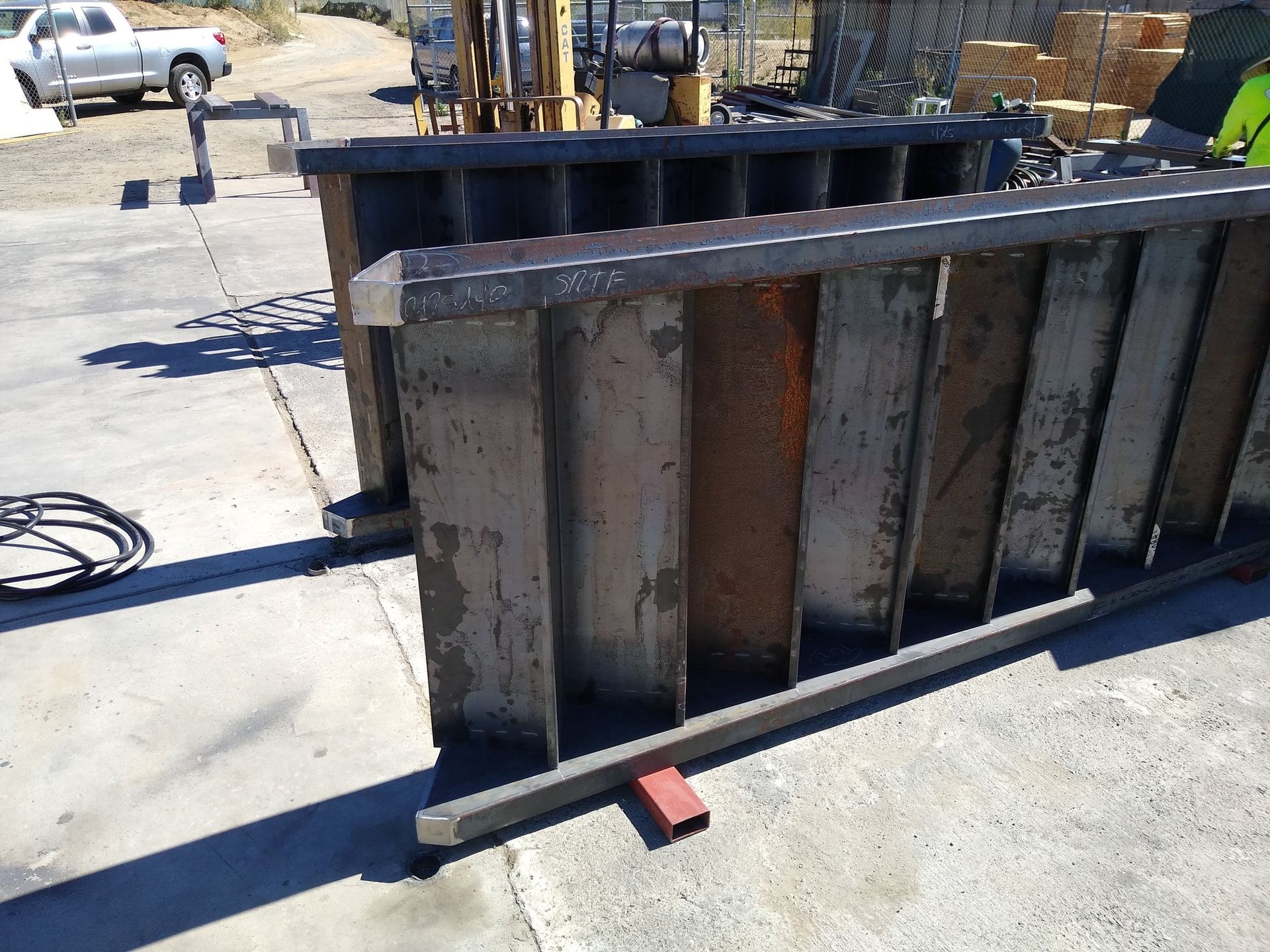 A large metal structure is sitting on the ground in a parking lot