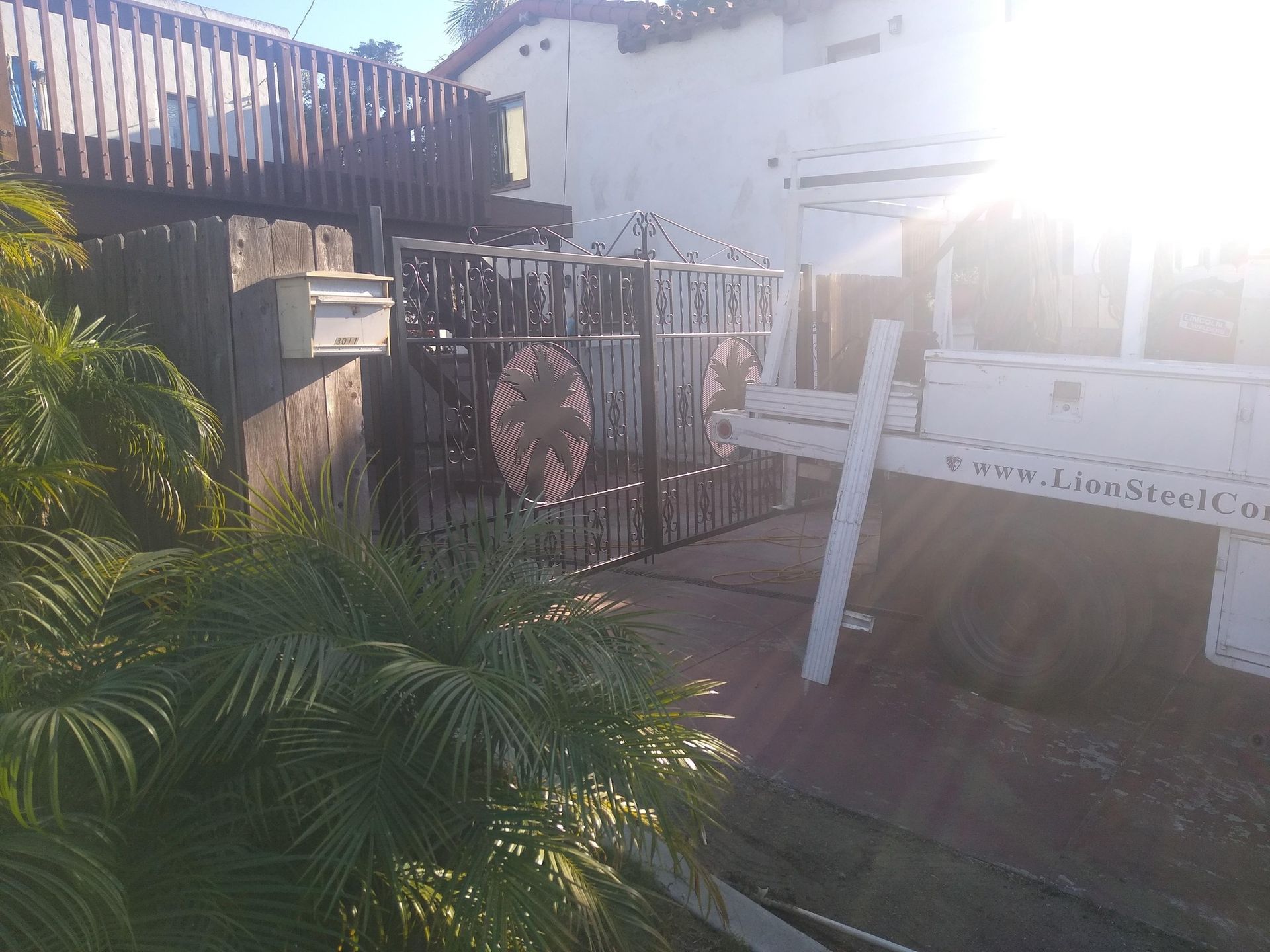 The sun is shining through the fence of a house