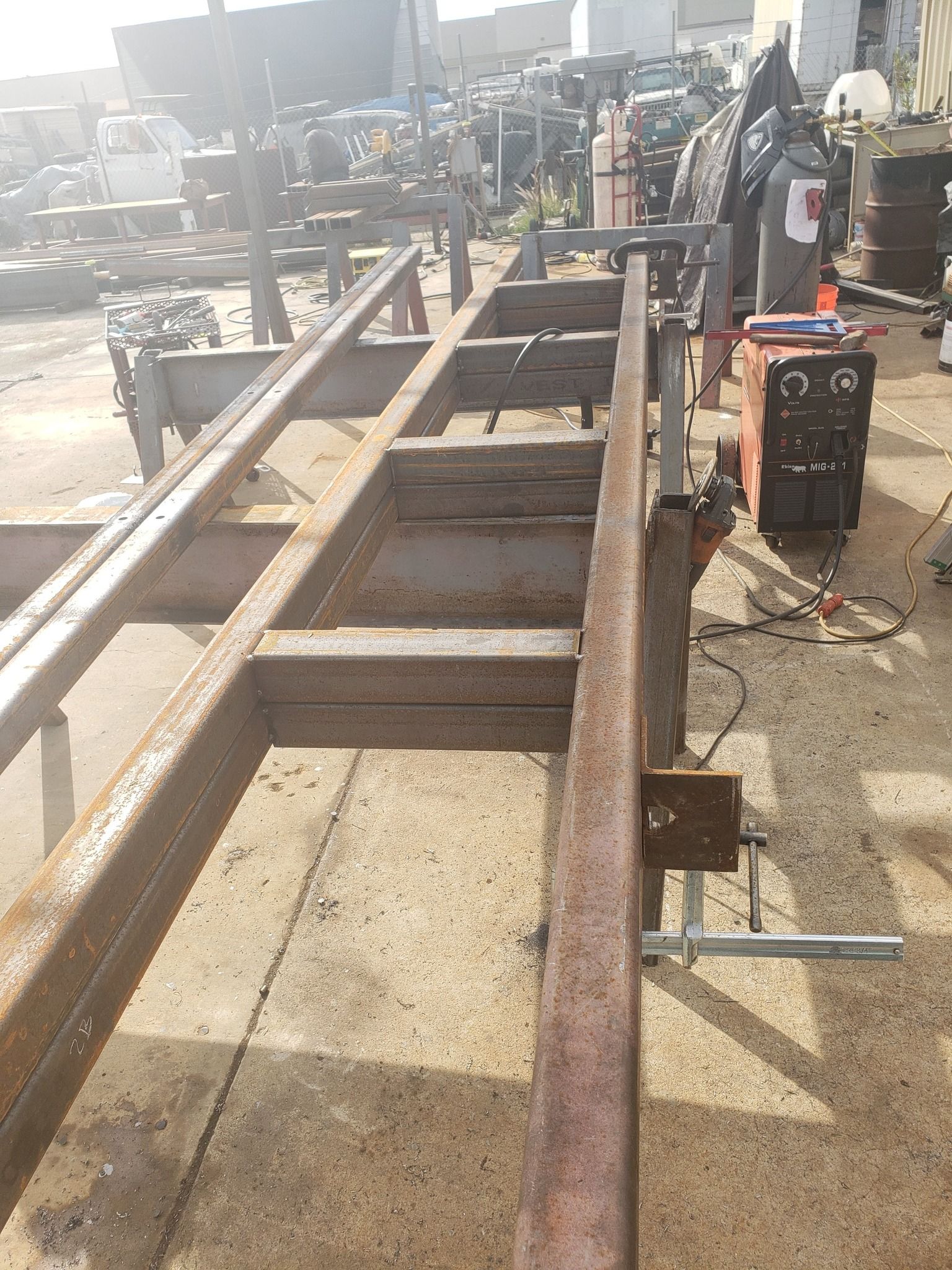 A person is working on a piece of metal in a garage.