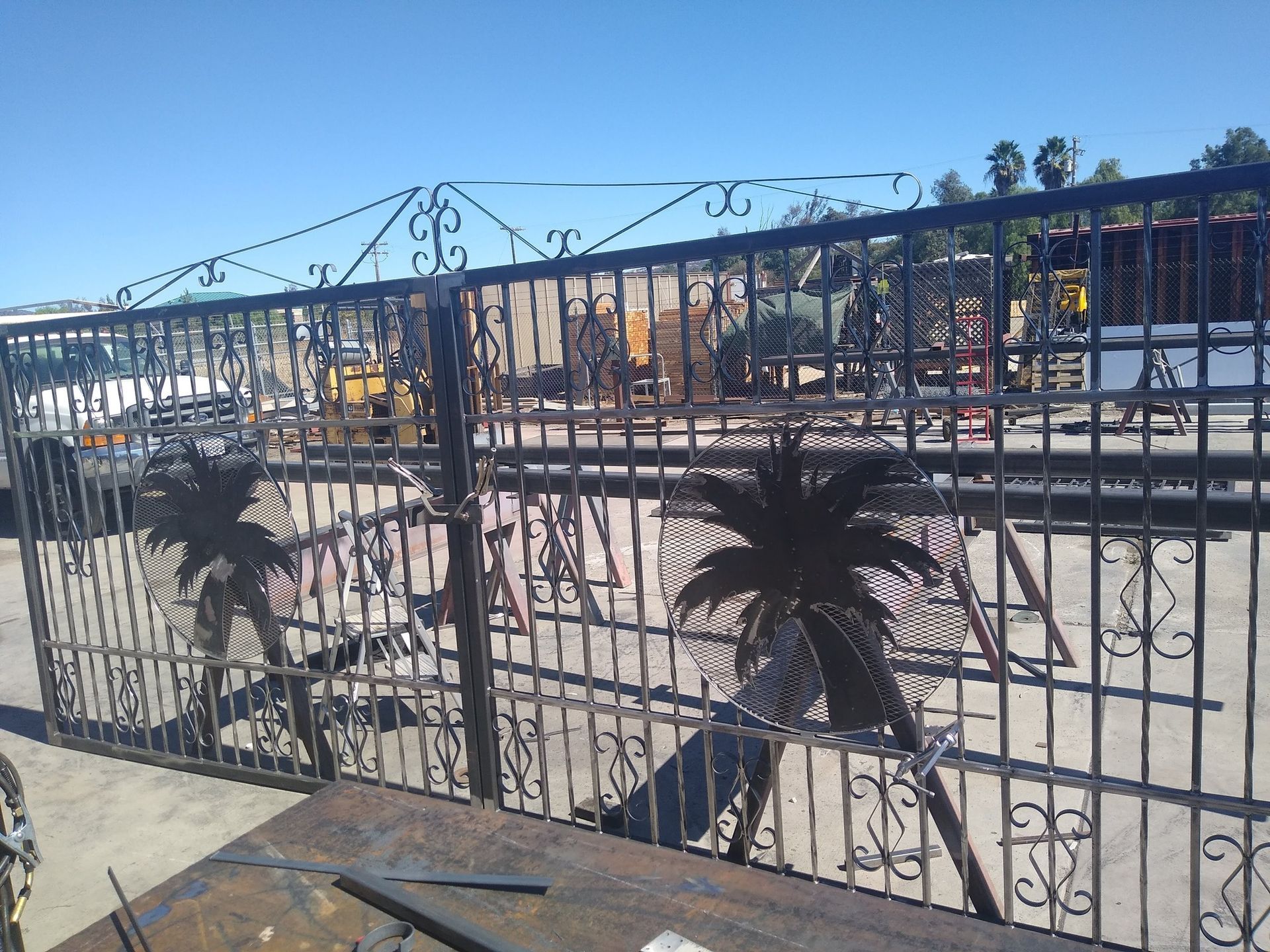 A wrought iron gate with palm trees on it