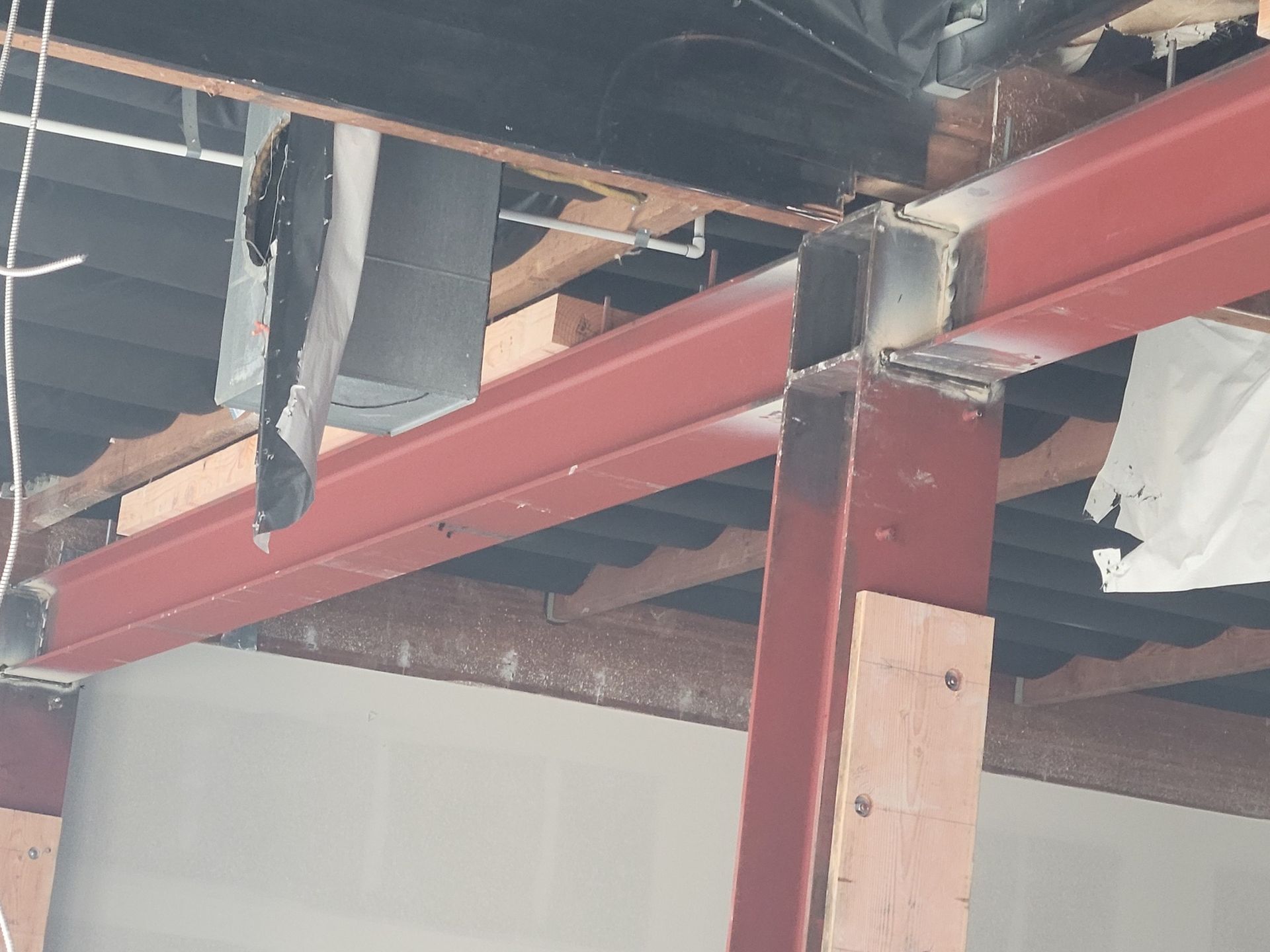 A red beam is hanging from the ceiling of a building