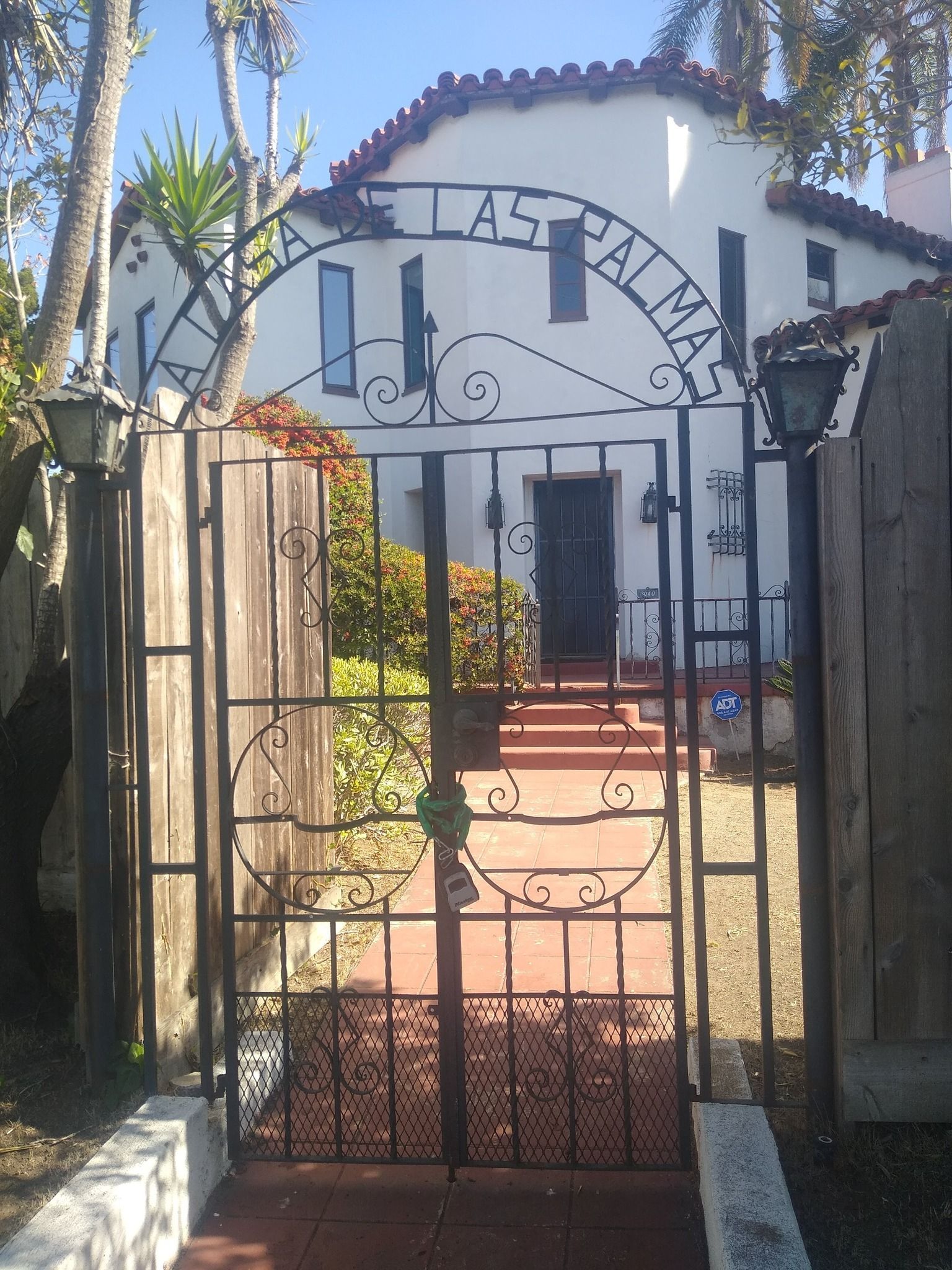 A wrought iron gate leading to a house that says las palmas