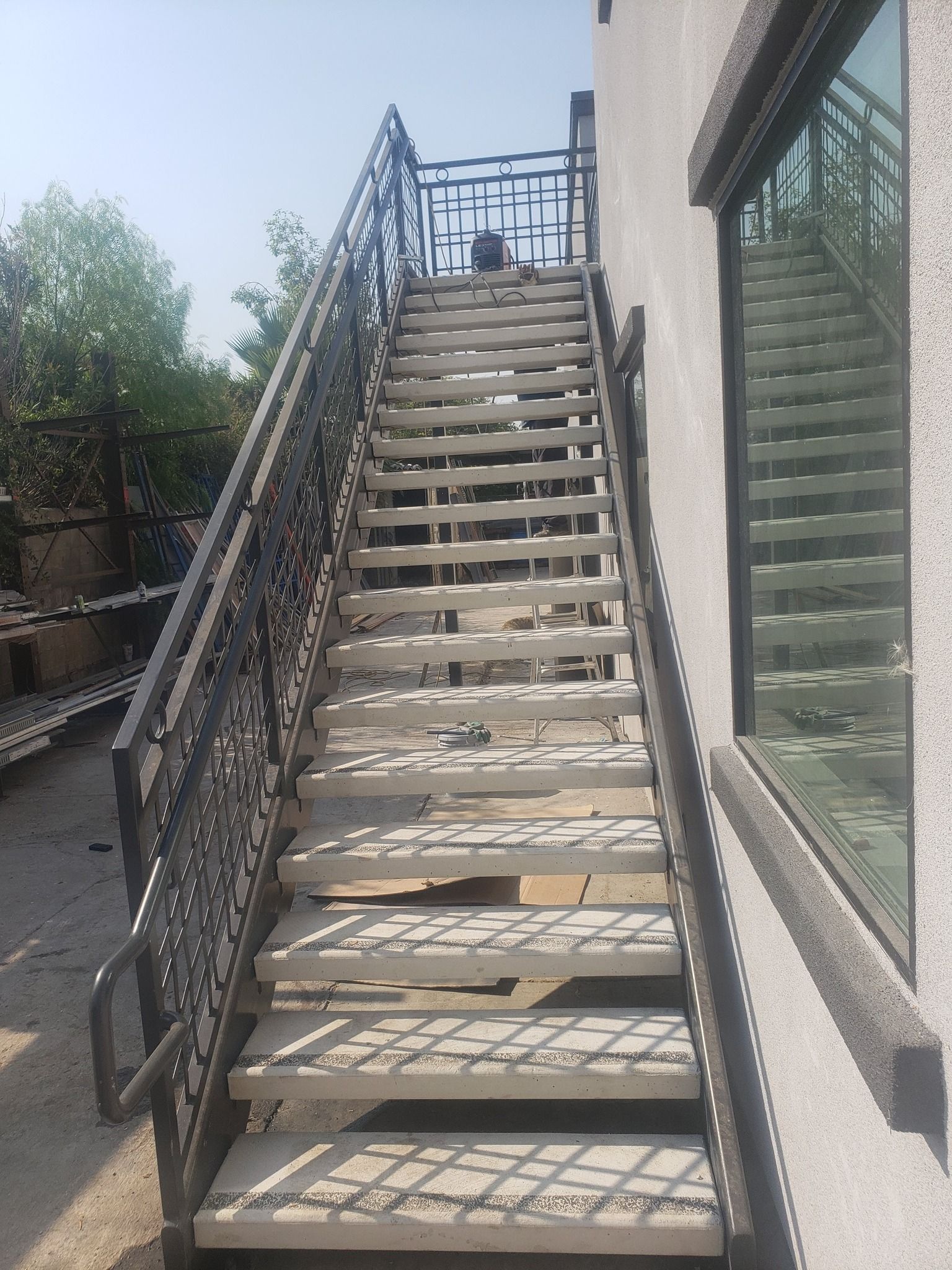 A set of stairs leading up to a building with a wrought iron railing.