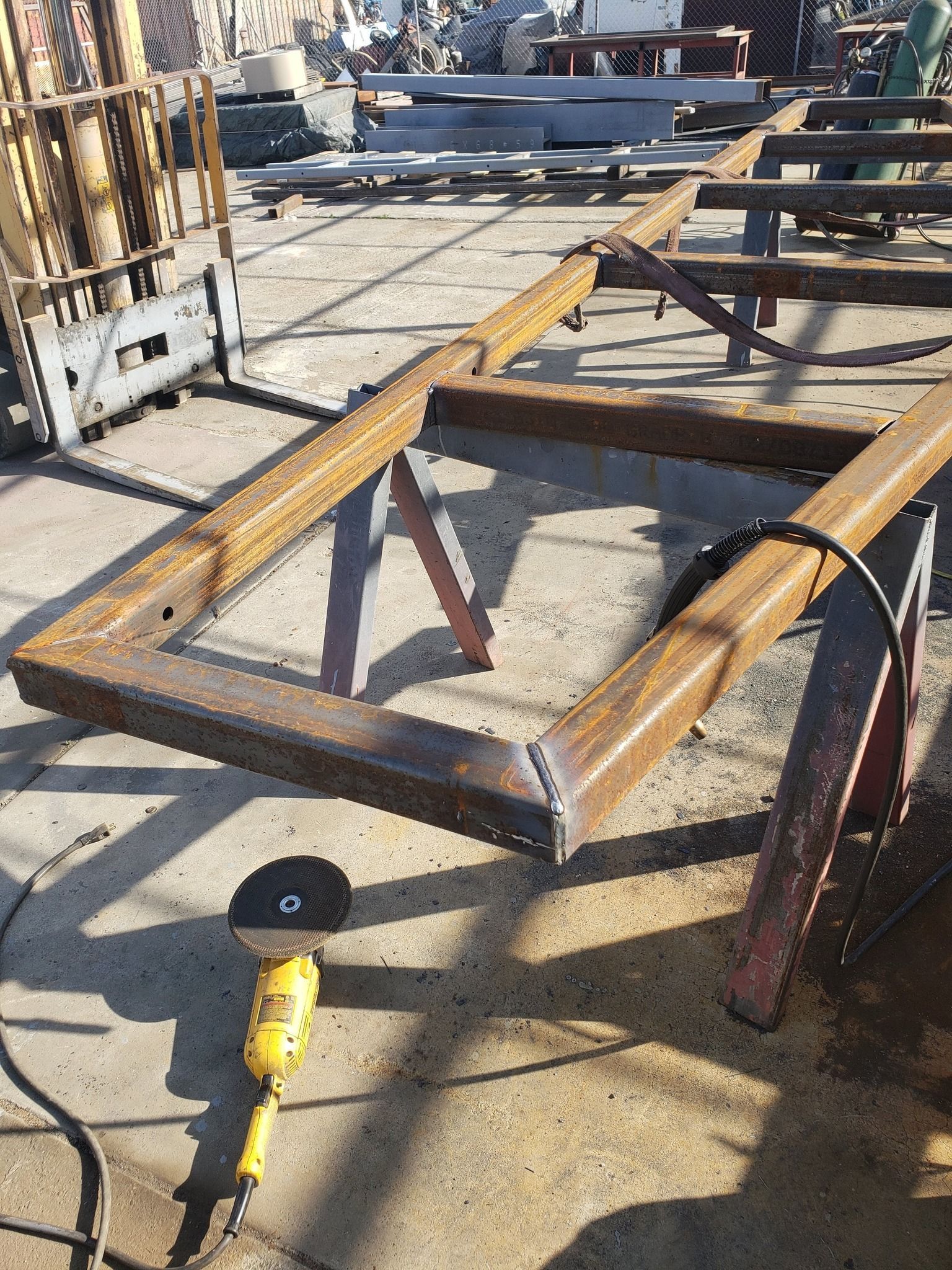 A metal frame is being worked on by a welding machine.