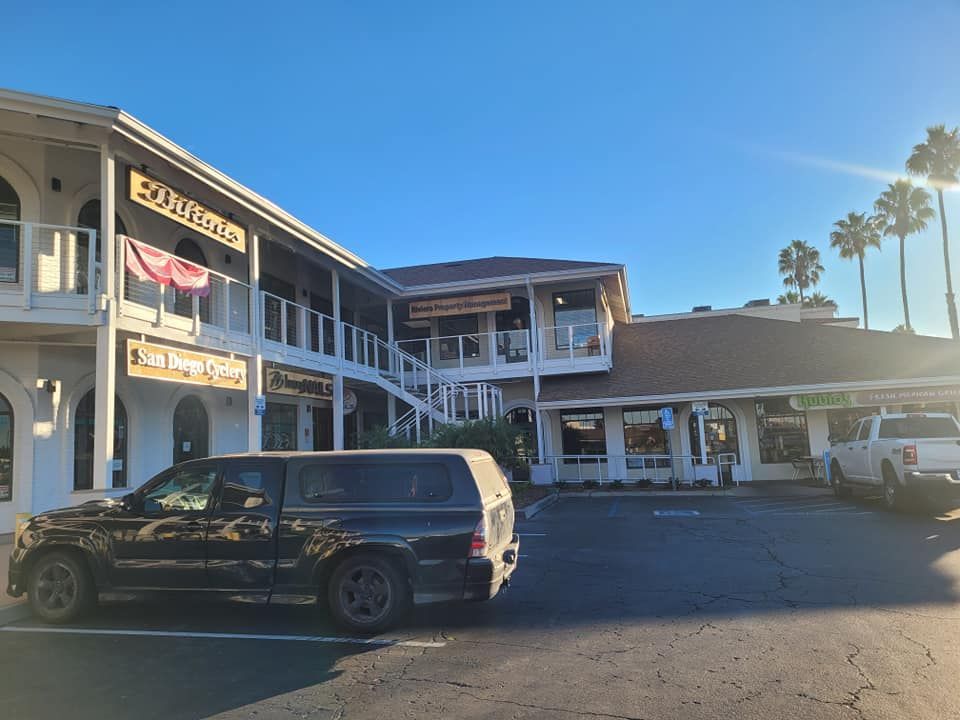 A black van is parked in front of a building.