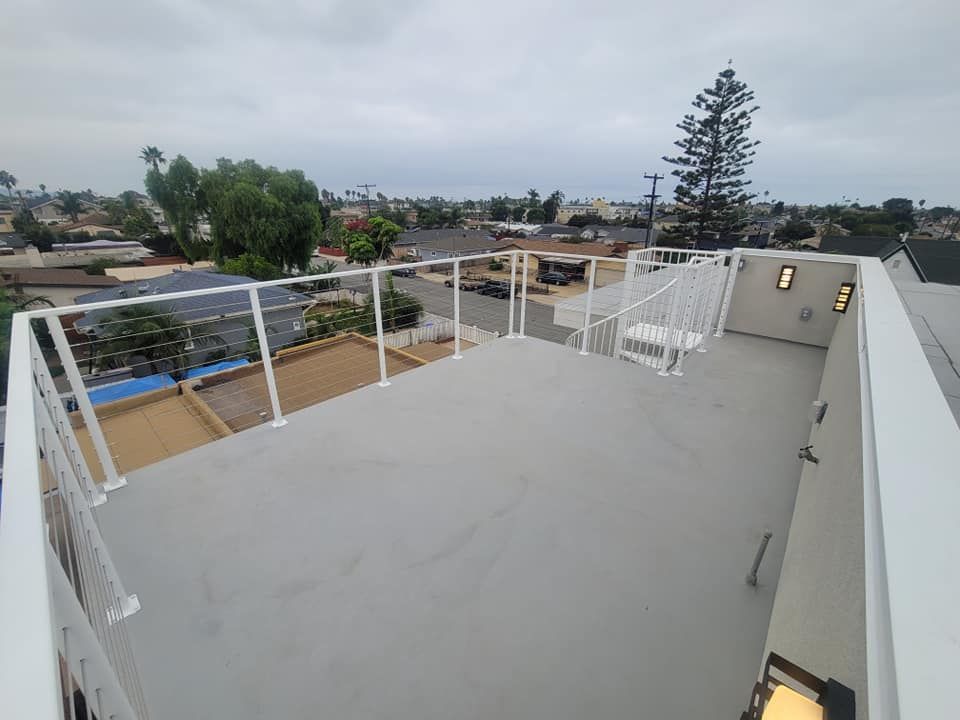 A rooftop deck with a railing and stairs leading up to it.