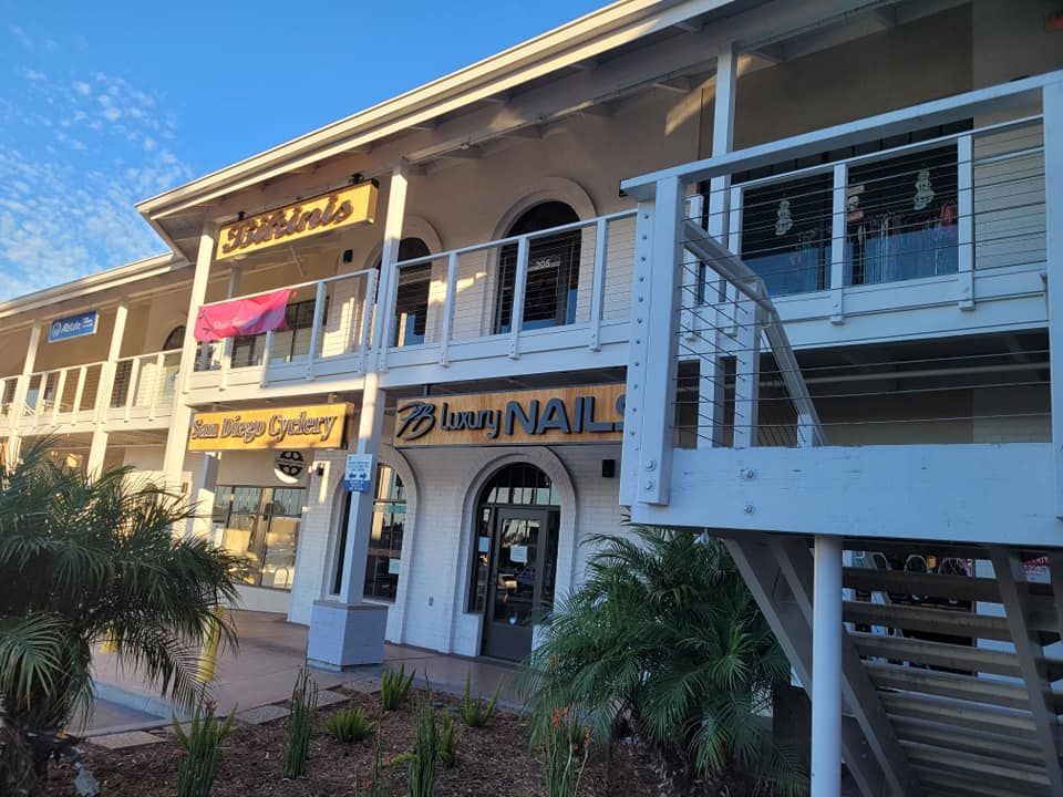 A building with stairs leading up to it and a sign that says lazy nail