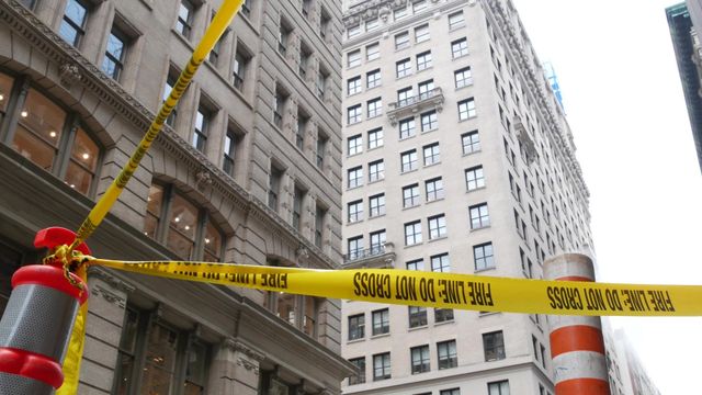 Two people examining electrical outlets in a room under construction.