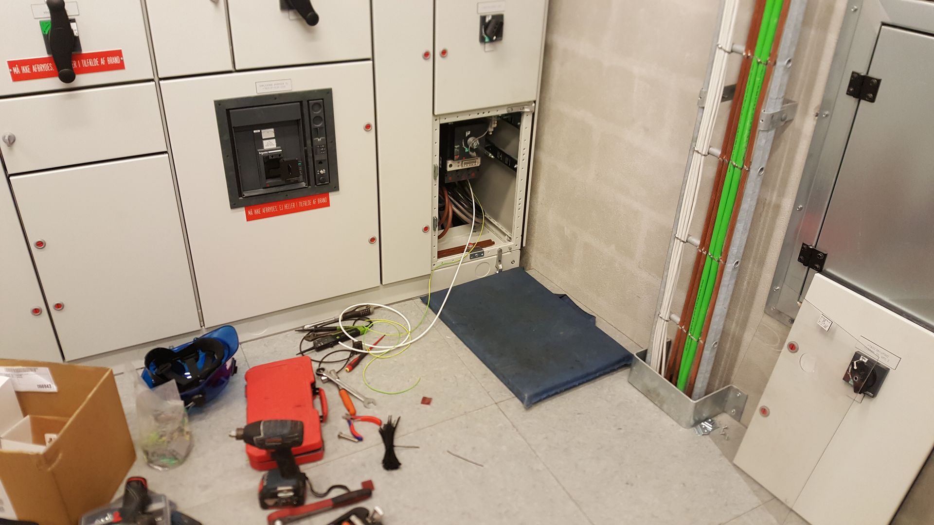 Et rum med en masse elektrisk udstyr på gulvet.