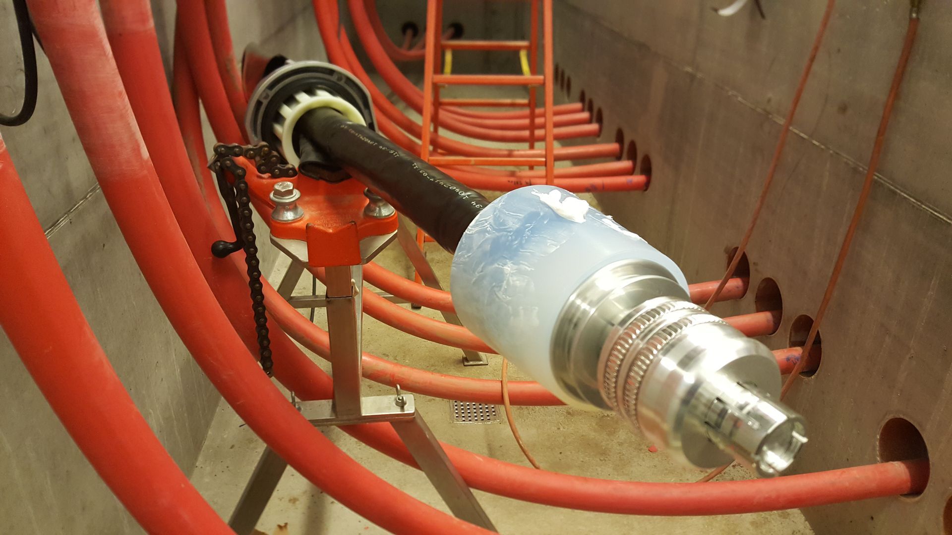 En masse røde rør bliver installeret i en tunnel.