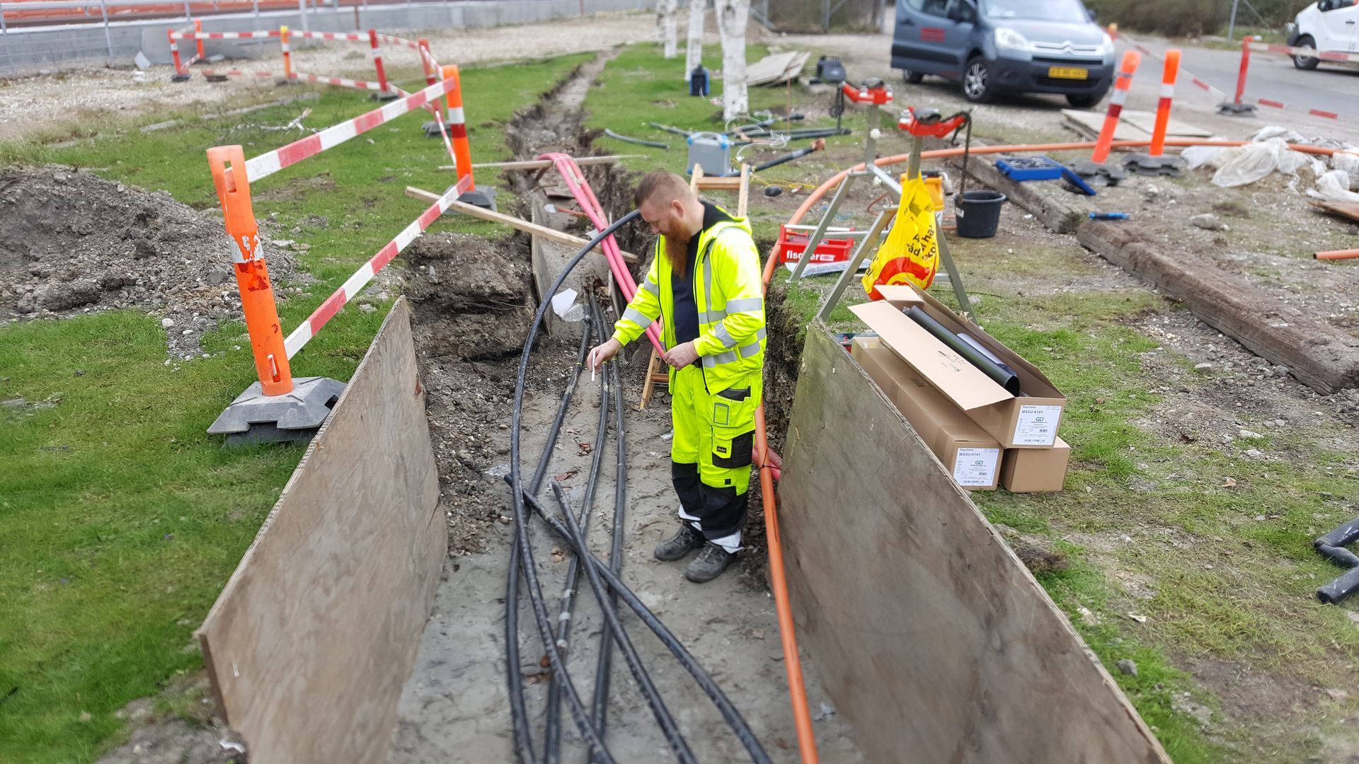 En mand i en gul sikkerhedsvest arbejder på en byggeplads.