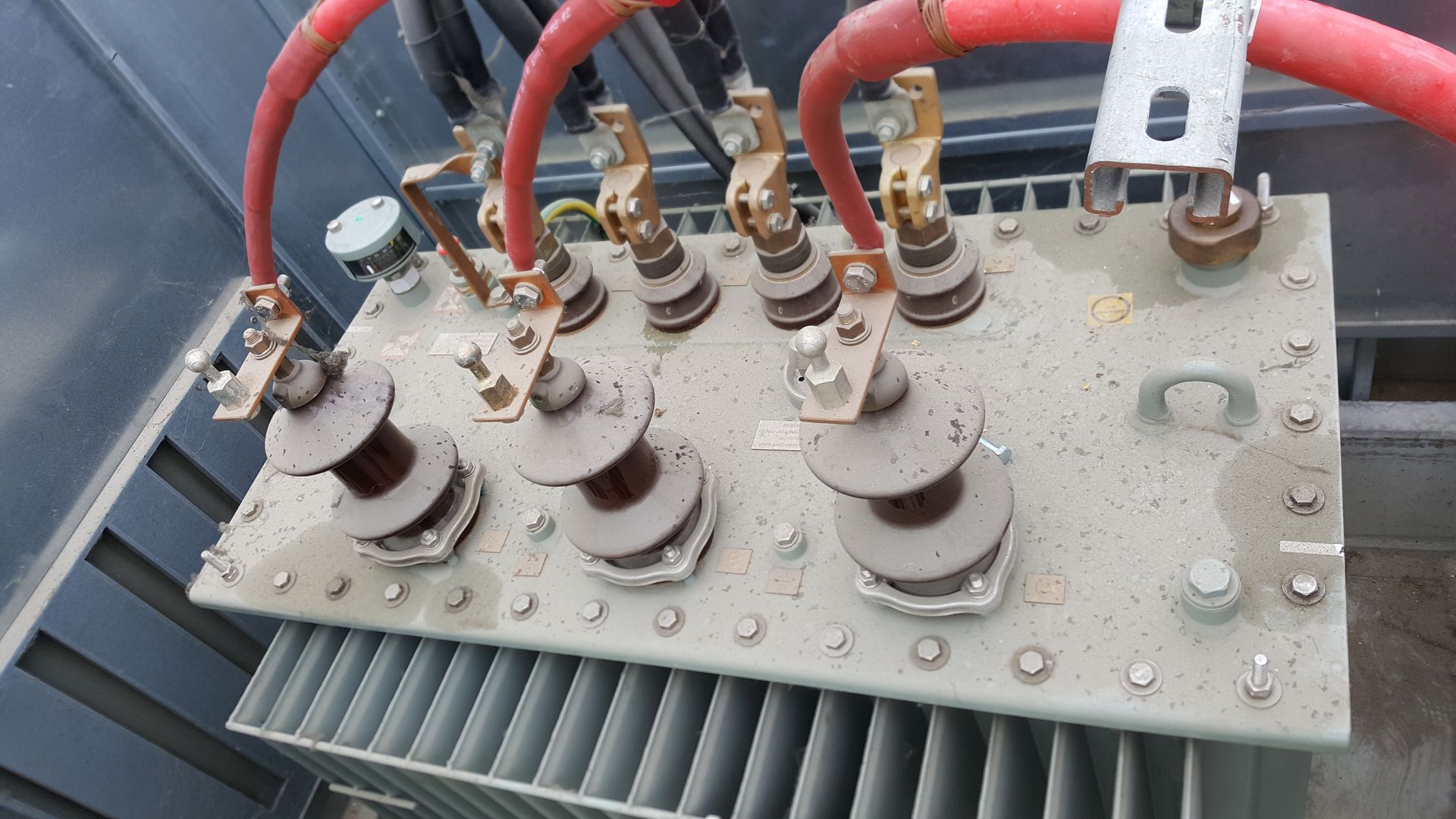 Et nærbillede af en transformer med røde ledninger, der kommer ud af den.