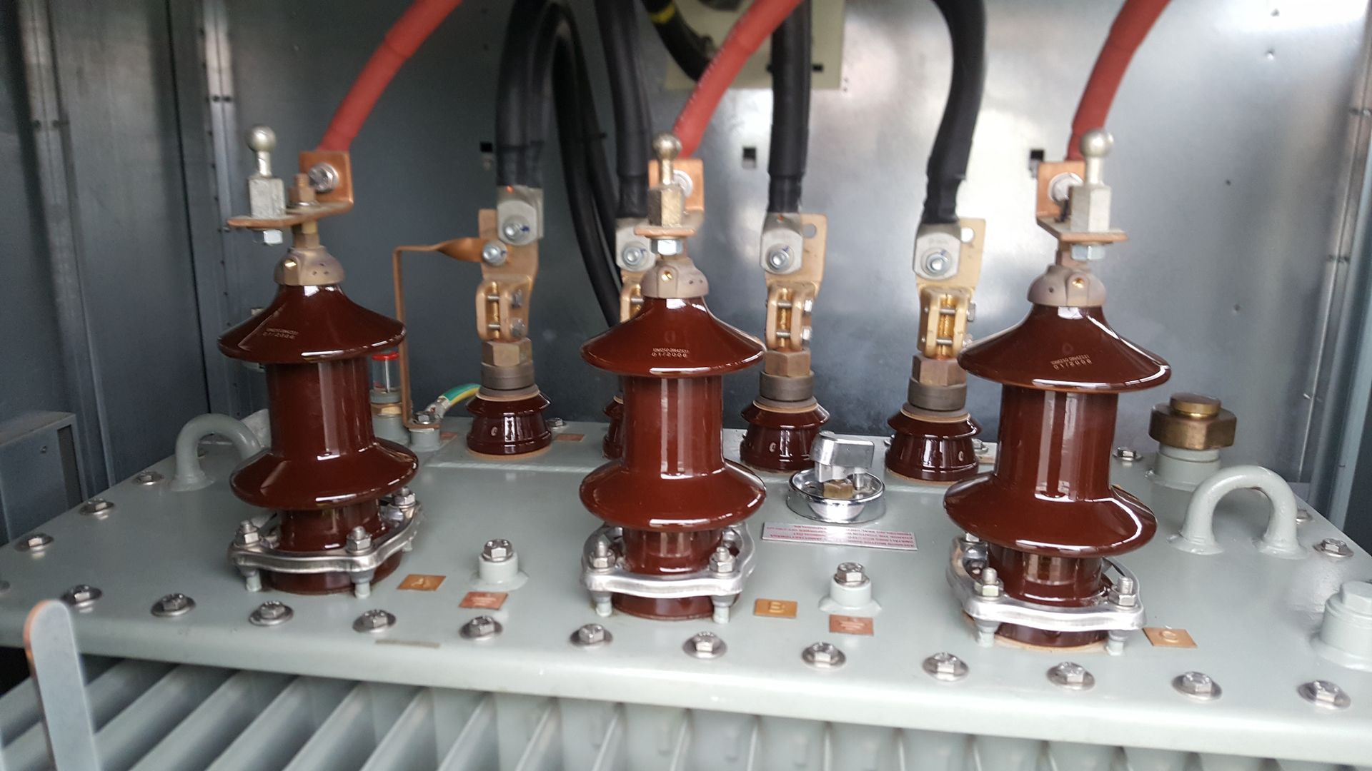 Et nærbillede af en transformer med en masse ledninger, der kommer ud af den