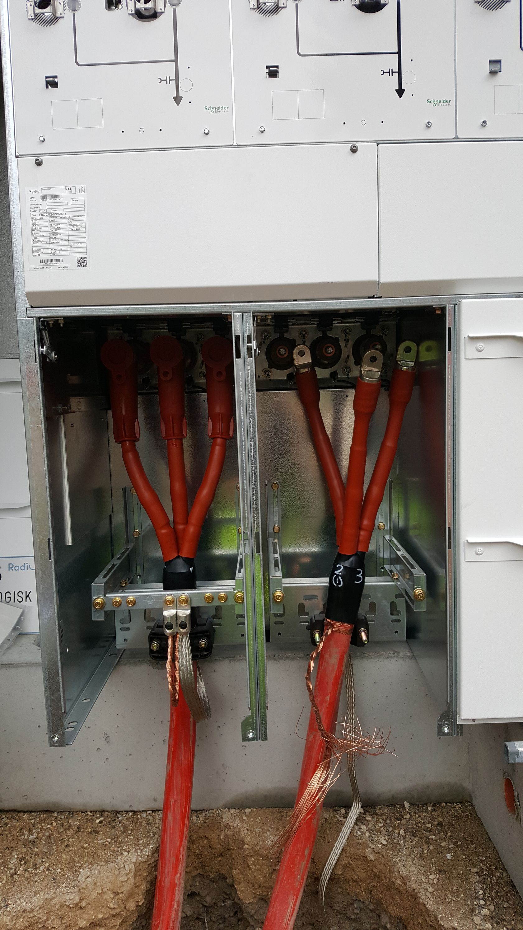 Et nærbillede af en el-dåse med røde ledninger, der kommer ud af den.