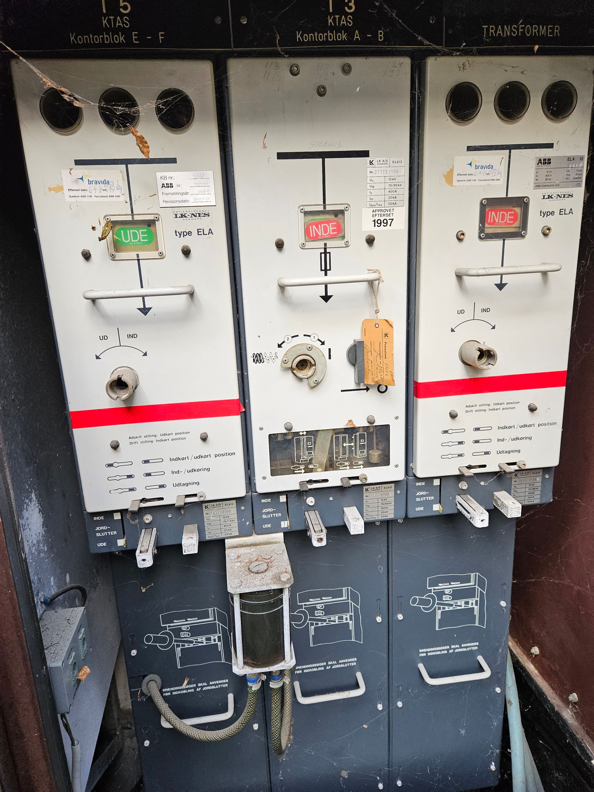 En række elektriske paneler med en rød knap, hvorpå der står 'nødsituation'