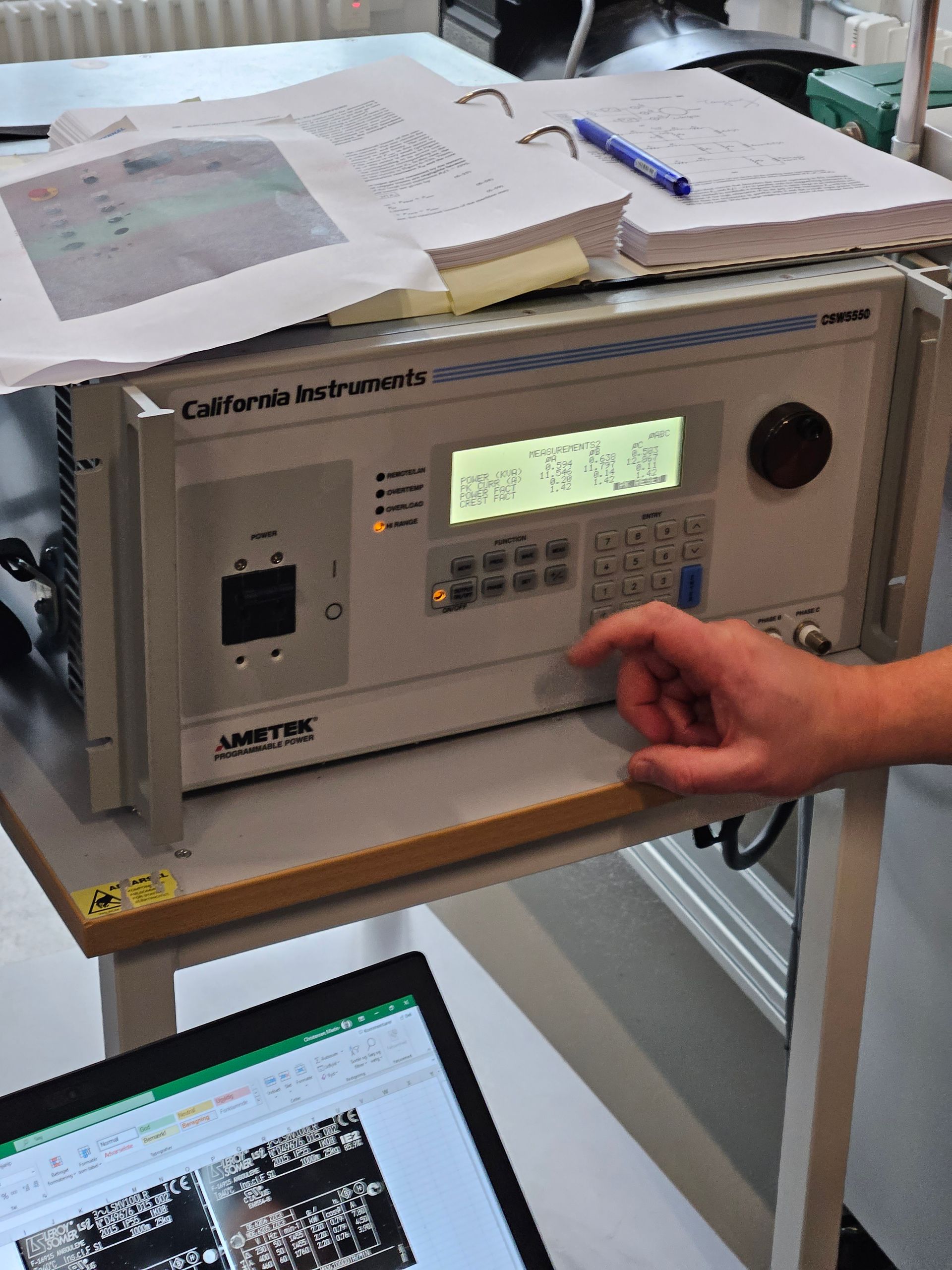 En person trykker på en knap på en enhed, hvorpå der står 