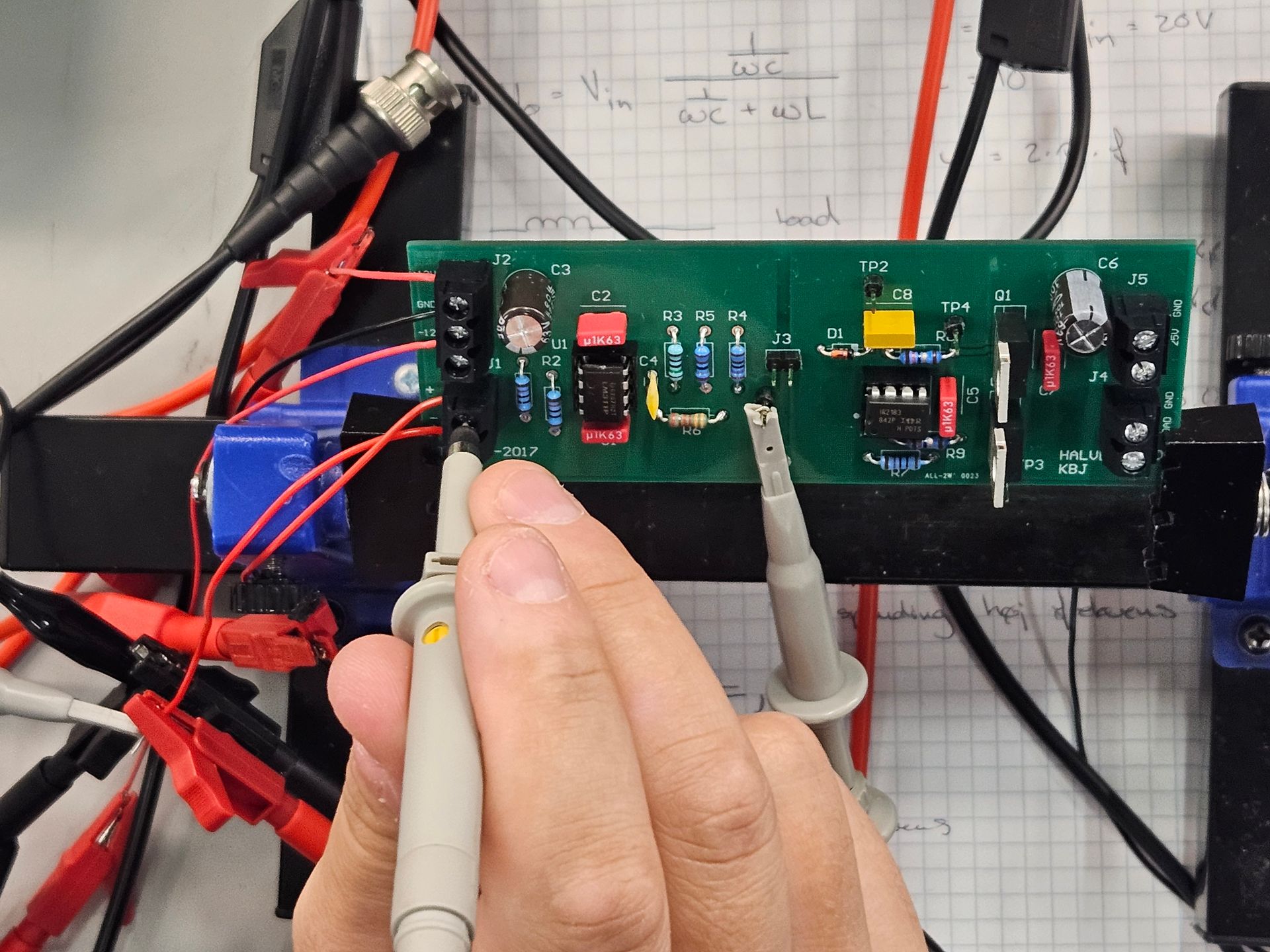 En person tester et printkort med et multimeter