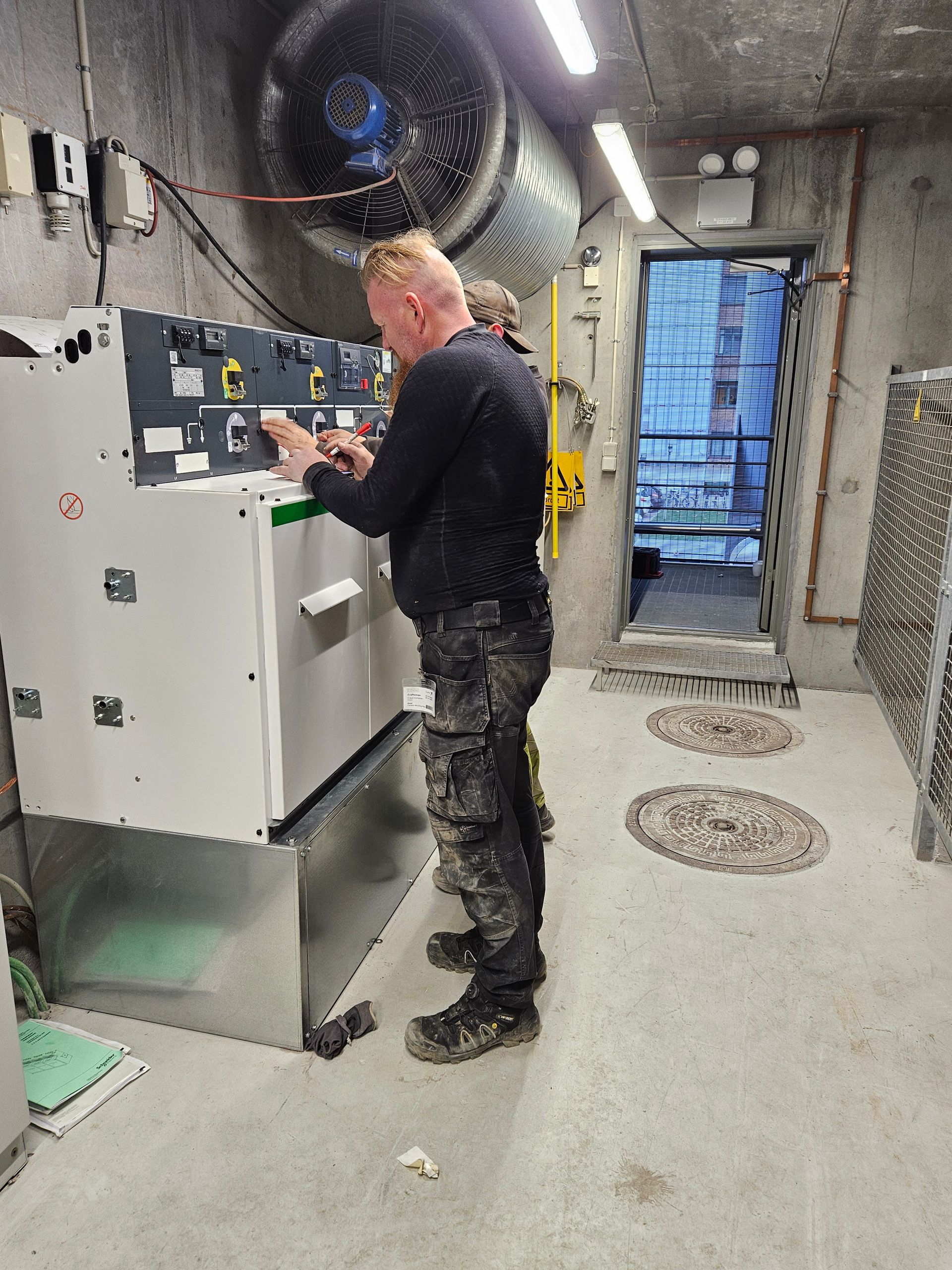 En mand arbejder på en maskine i et rum.