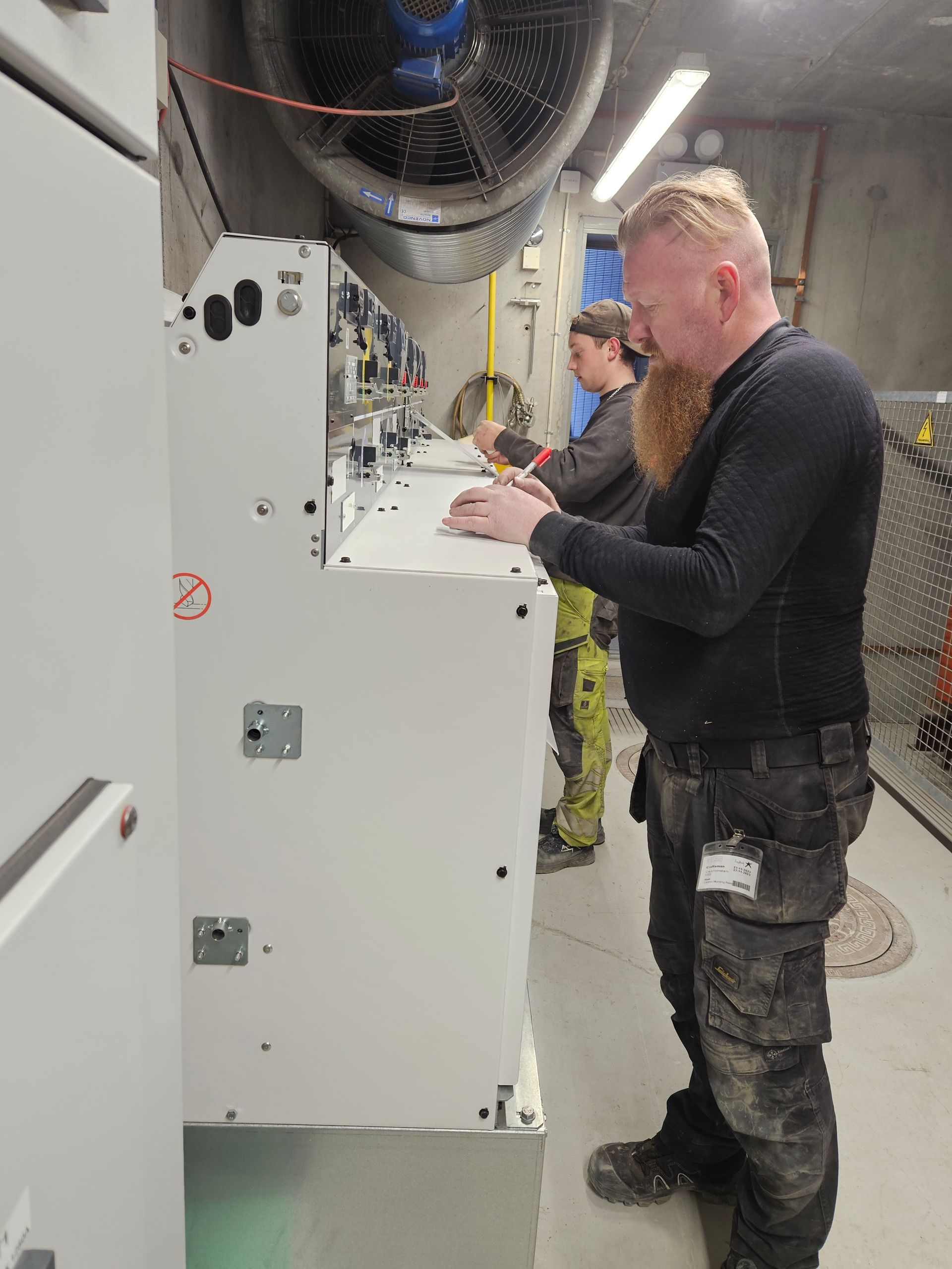 En mand i en sort skjorte arbejder på en maskine