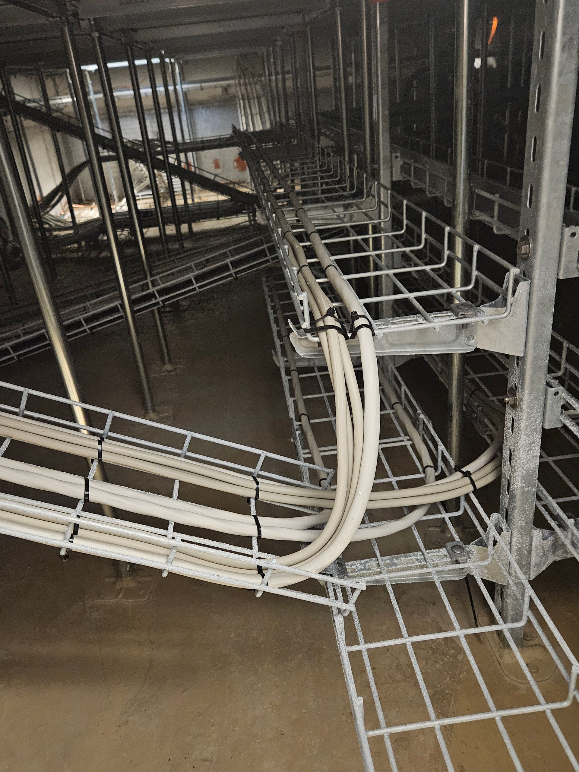 En masse ledninger hænger fra loftet på en bygning.