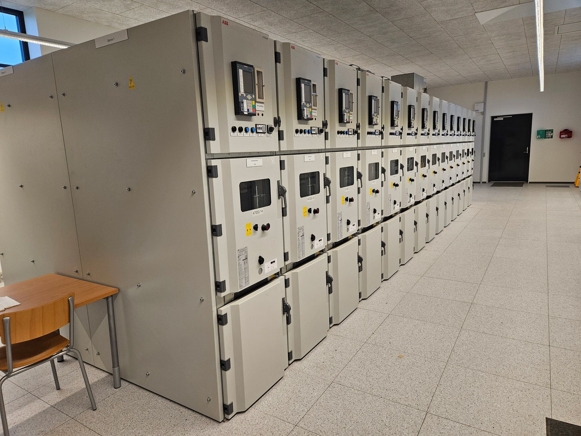 En række elskabe i et rum med et bord og stole.