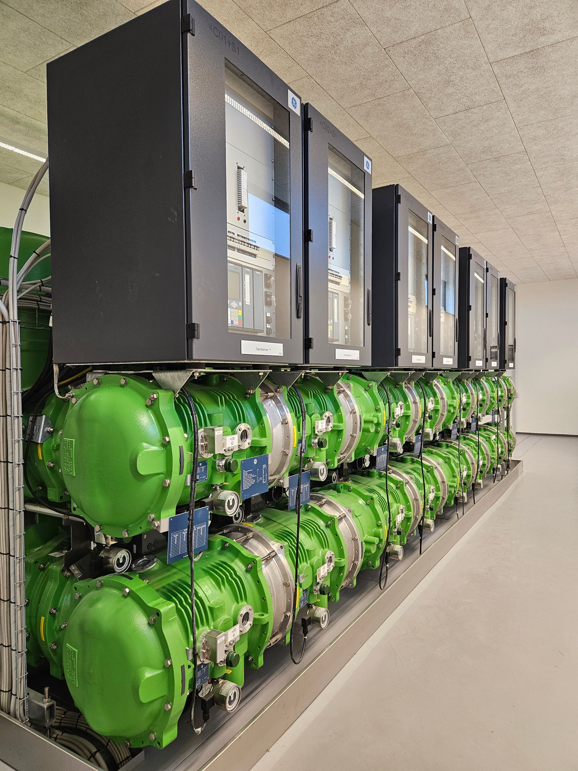 En række grønne rør er opstillet i et rum.