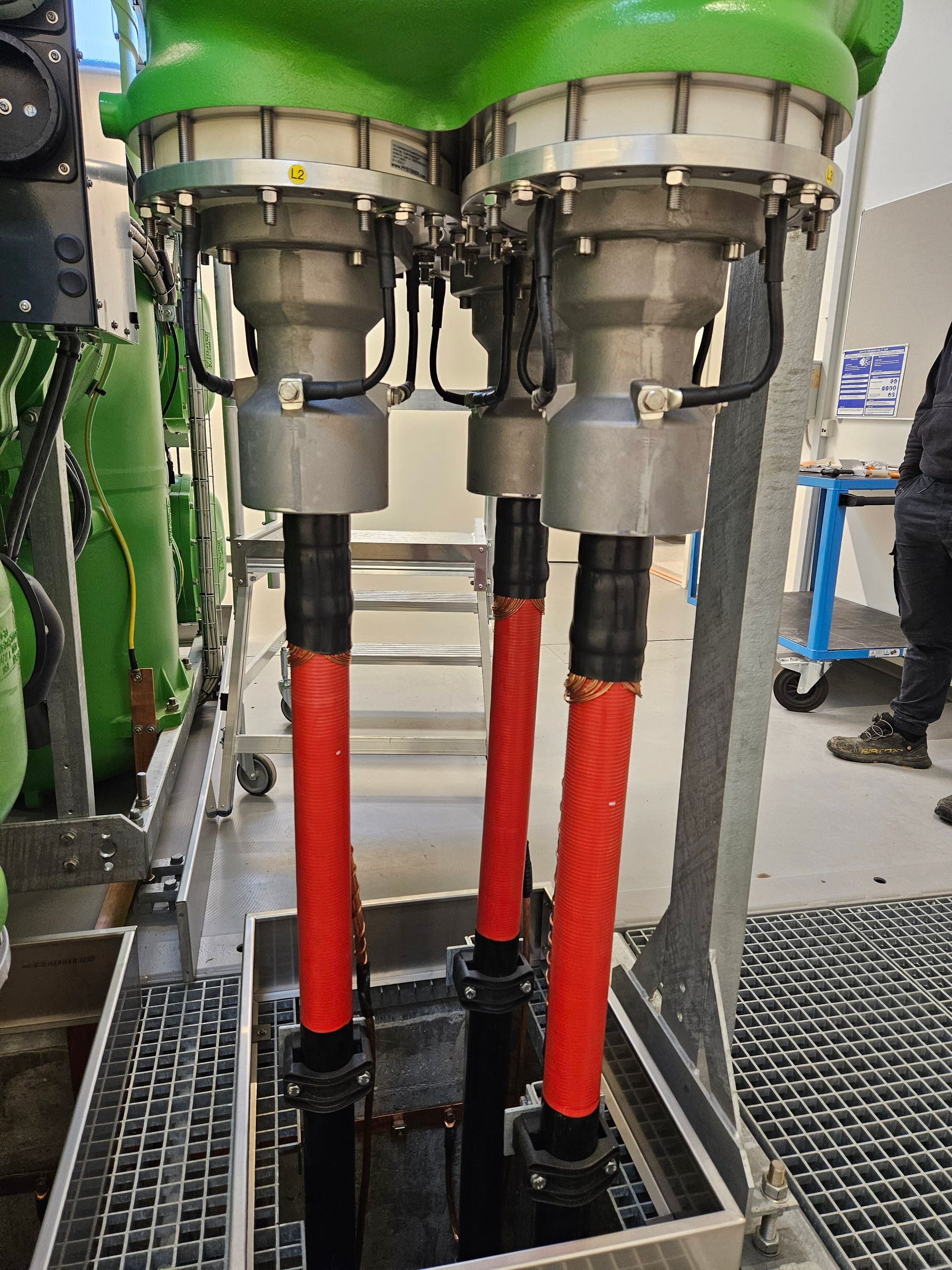 En grøn maskine med tre røde rør fastgjort til den.