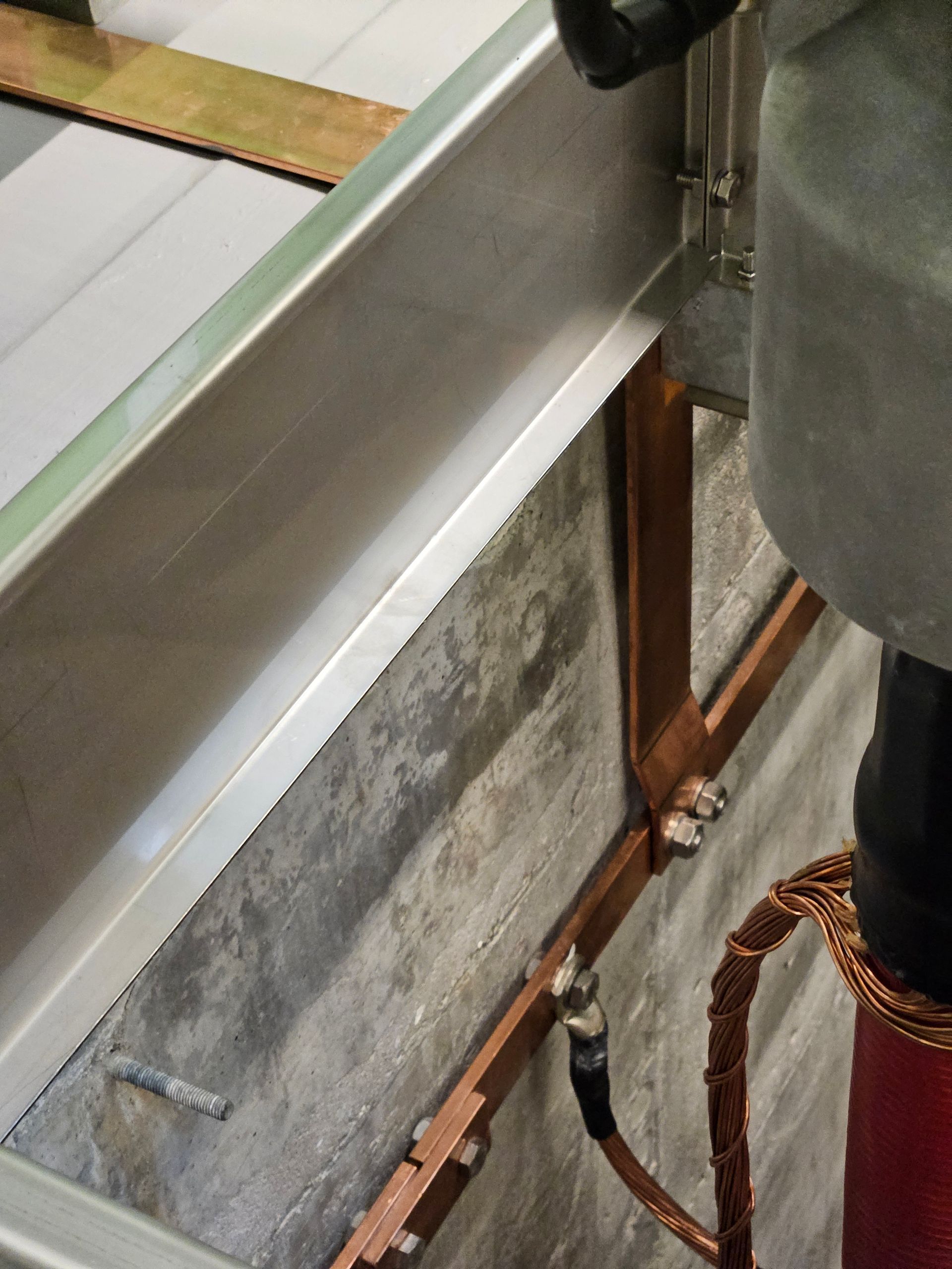 En person står ved siden af ​​en metalbjælke